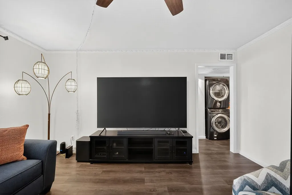Living area featuring wood-finish flooring, white walls, and crown molding