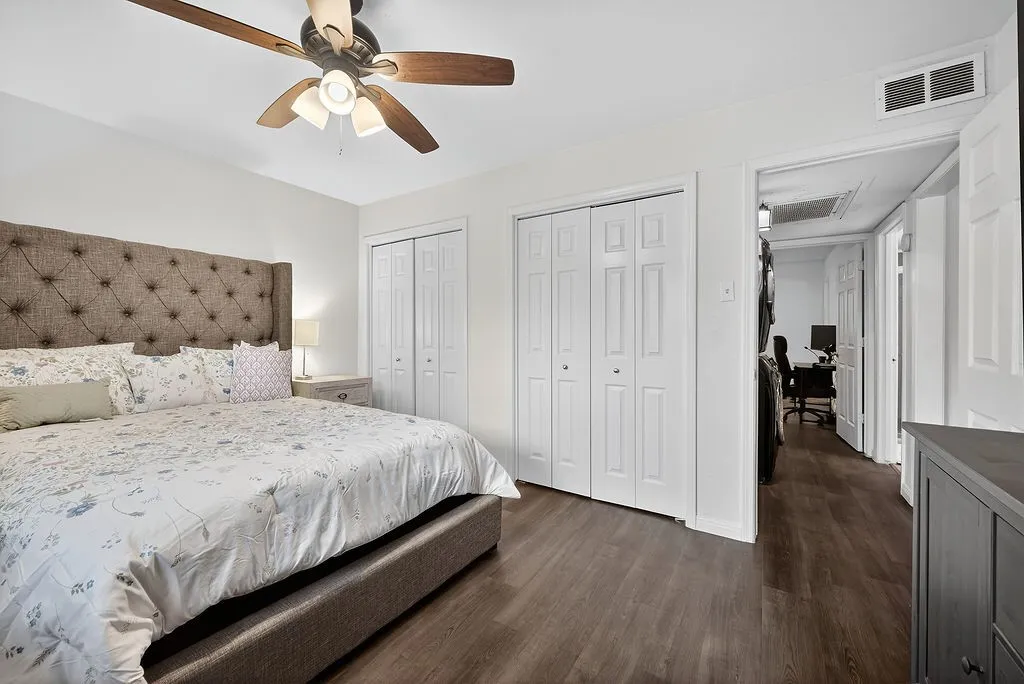 Bedroom featuring wood-finish flooring, white walls, and a ceiling fan with integrated lighting