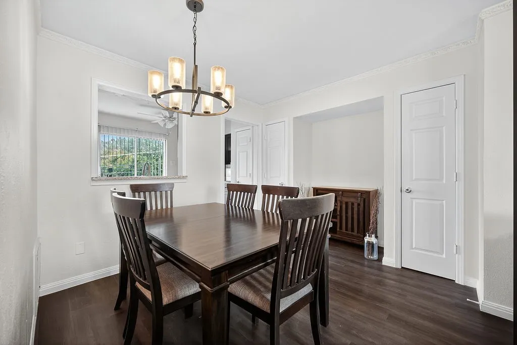 Dining area featuring wood-finish flooring and crown molding