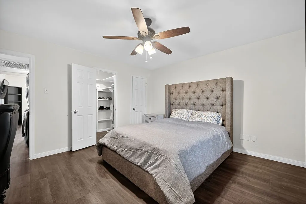 Interior room featuring wood-finish flooring, a ceiling fan with integrated lighting, and neutral wall paint