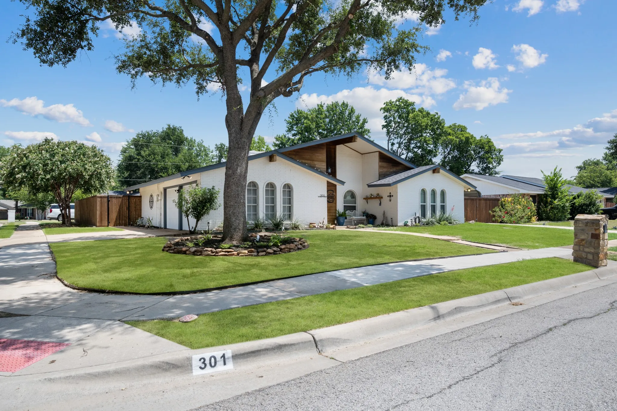 Modern residential home featuring a clean-lined white exterior with geometric architectural detailing and a sloped roof design