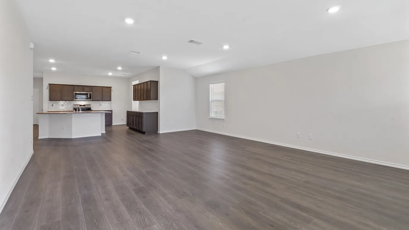 Open-concept living area with wood-finish flooring and recessed lighting