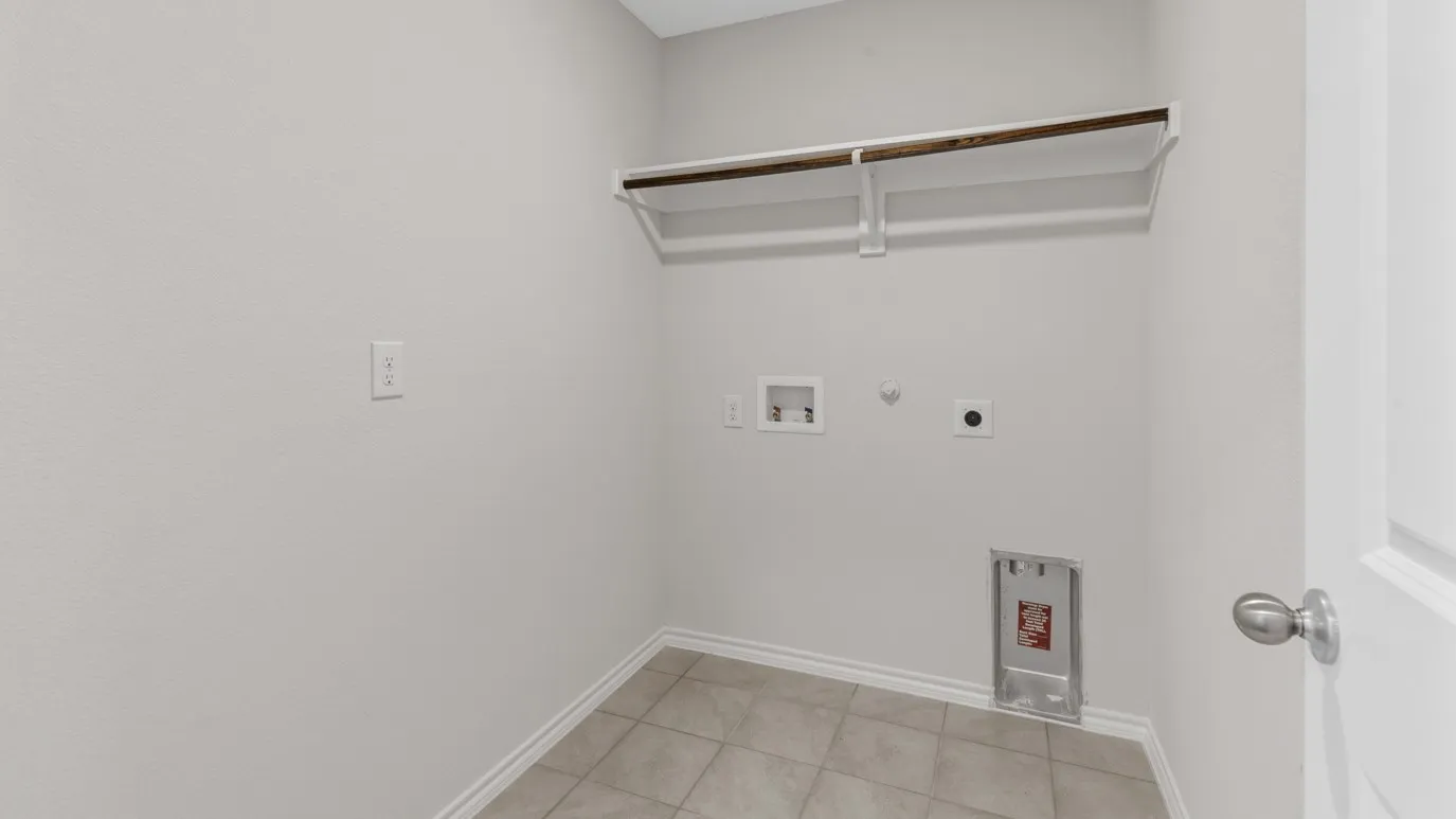 Utility closet featuring tile flooring, neutral wall paint, and a built-in clothing rod with shelving