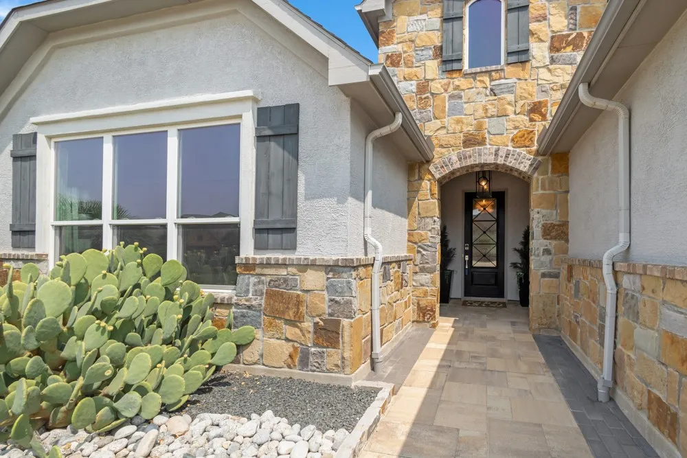 Impressive Entry has pavers, stonework and custom front door.