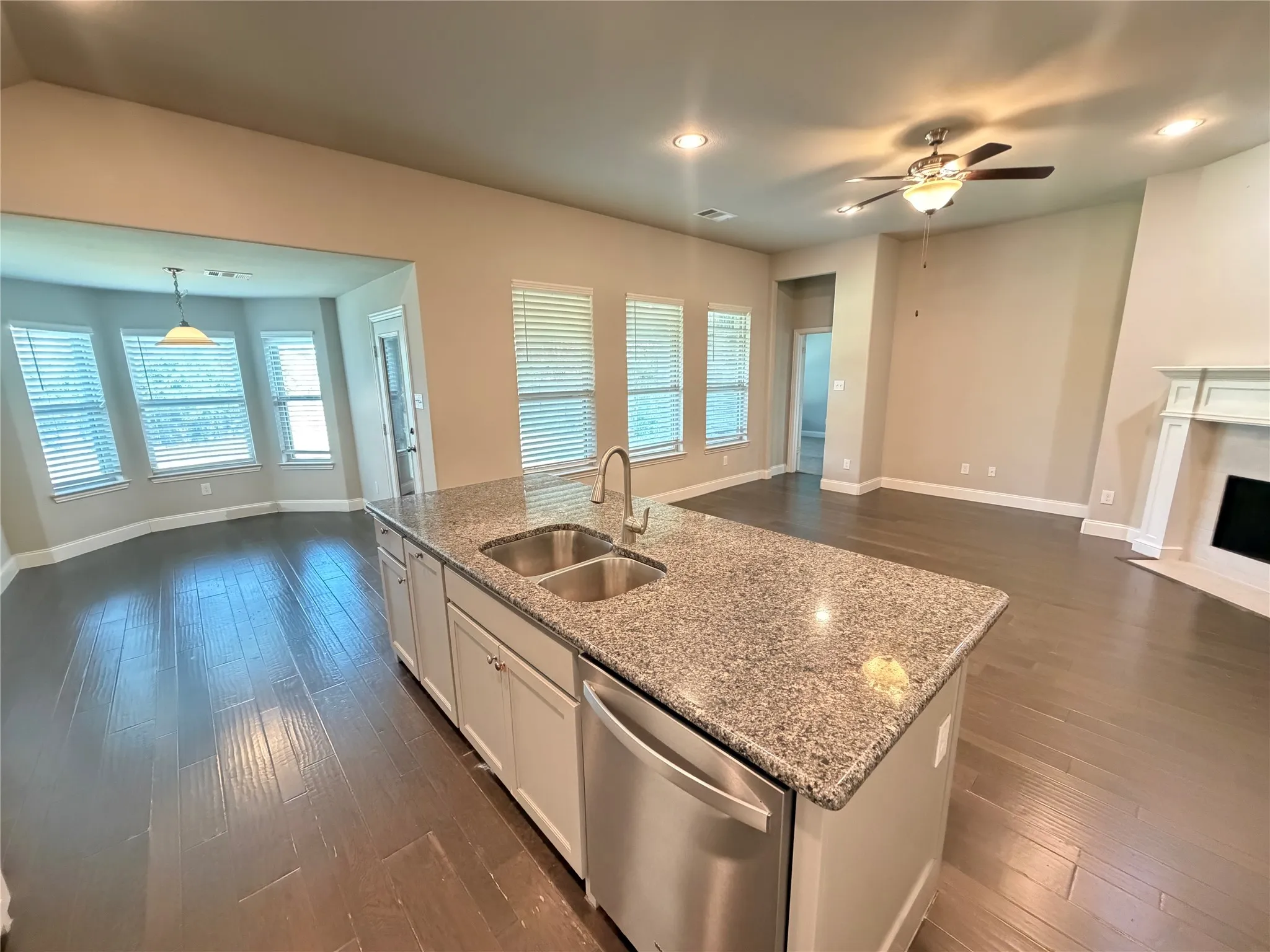 Kitchen island with a double basin stainless steel sink, granite countertop, and integrated dishwasher