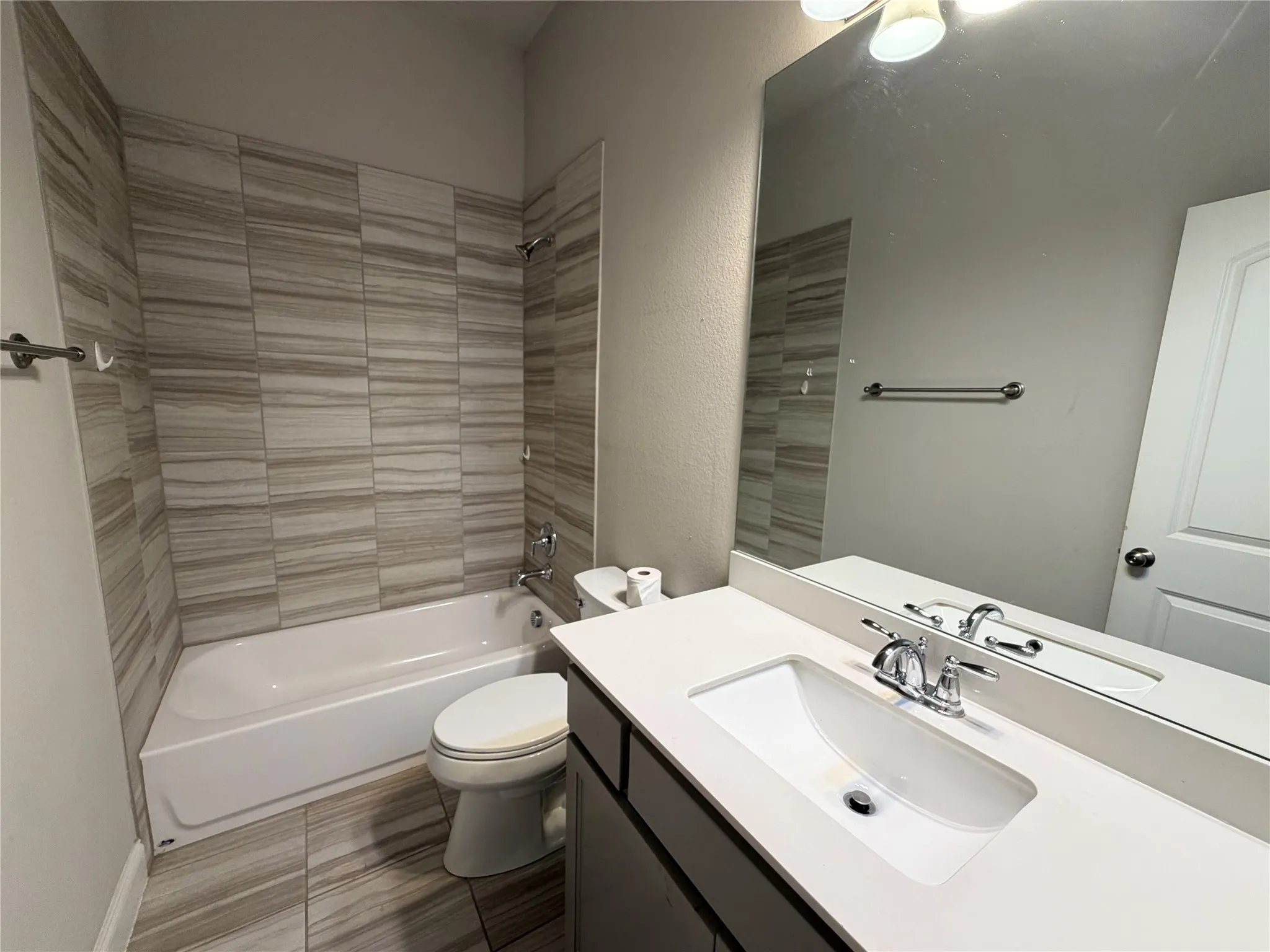 Bathroom featuring a neutral color palette, wood-look tile flooring, and a white vanity with an integrated sink