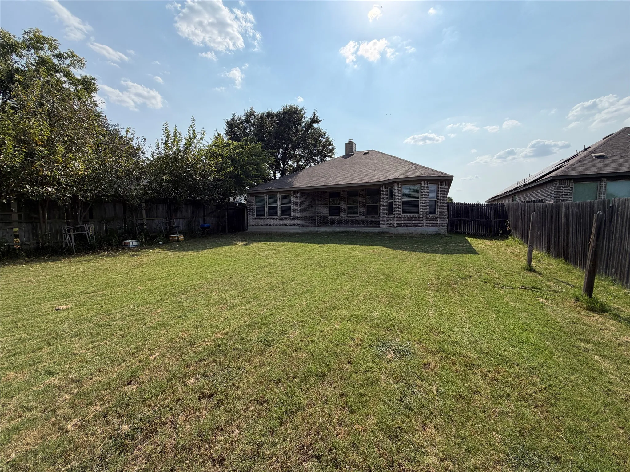 Expansive grassy yard with a privacy fence