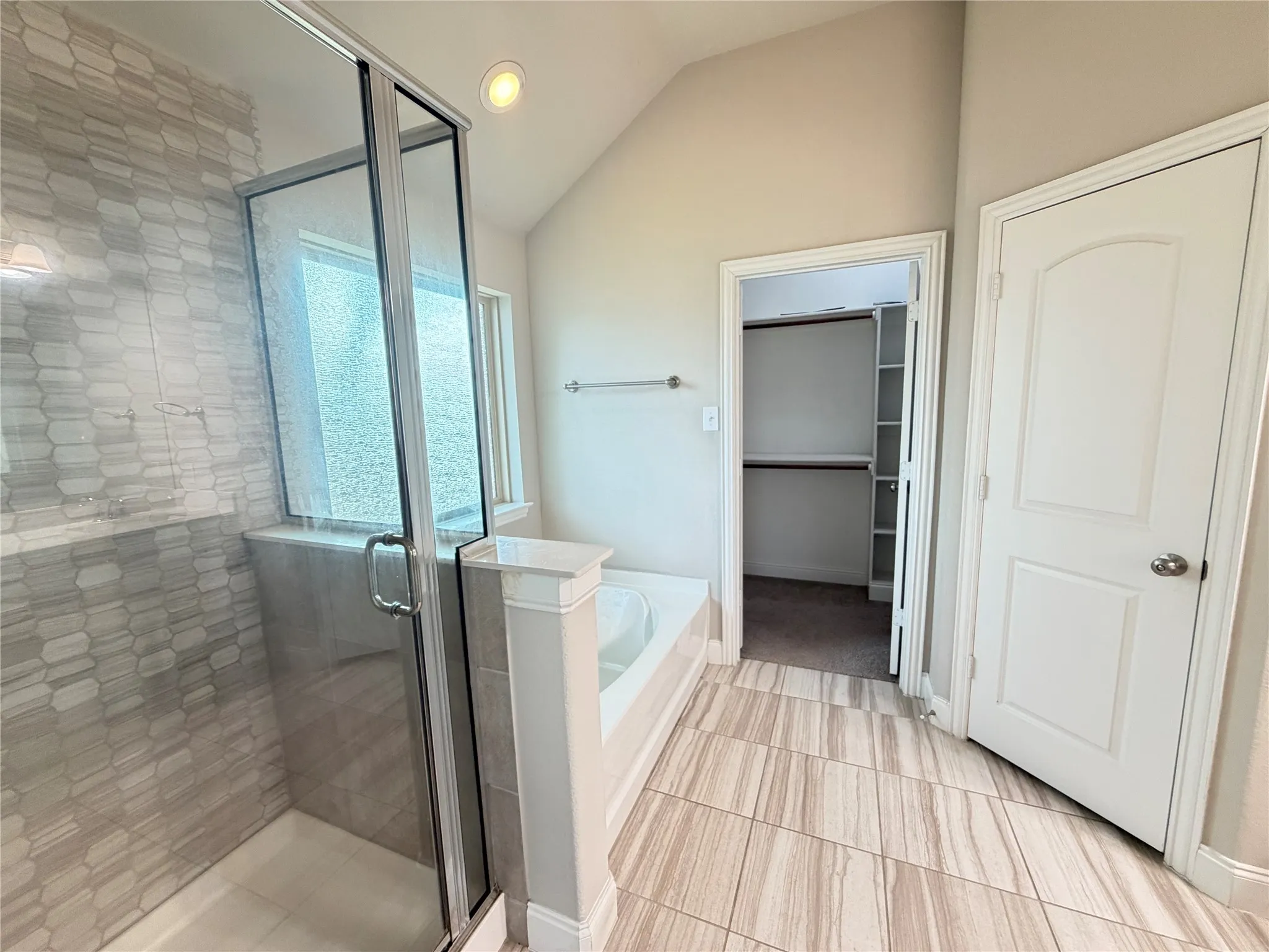 Bathroom featuring a glass-enclosed shower with honeycomb-patterned tile, an integrated bathtub, and wood-finish tile flooring