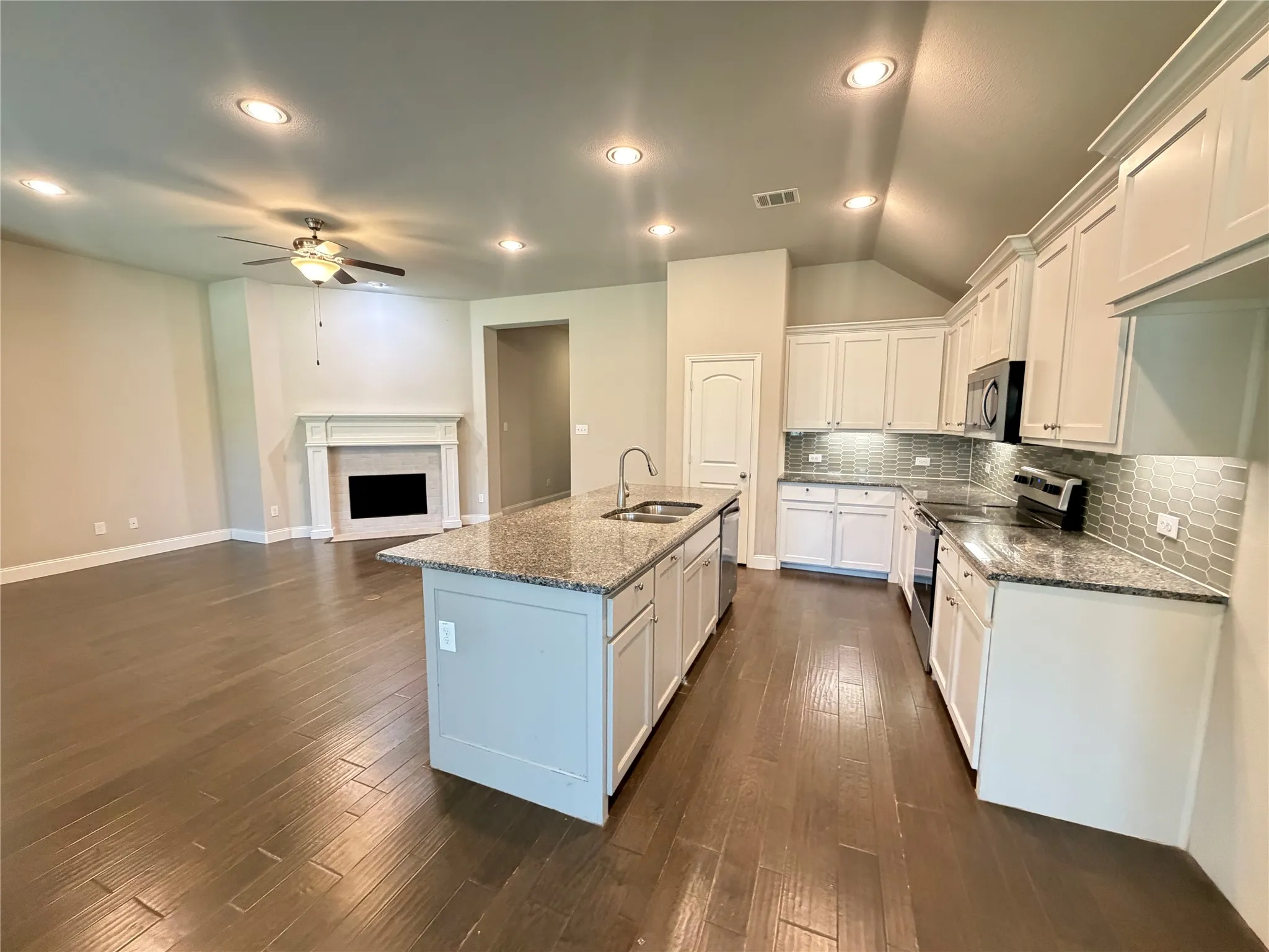 Open-concept kitchen and living area featuring wood-finish flooring
