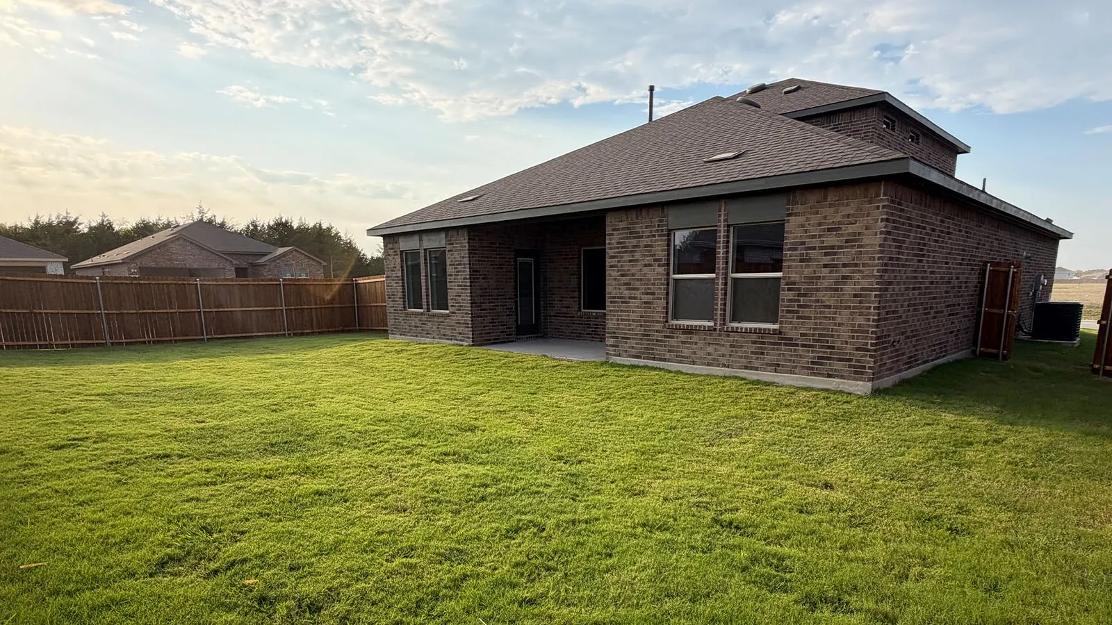 Expansive grass lawn with a full privacy fence