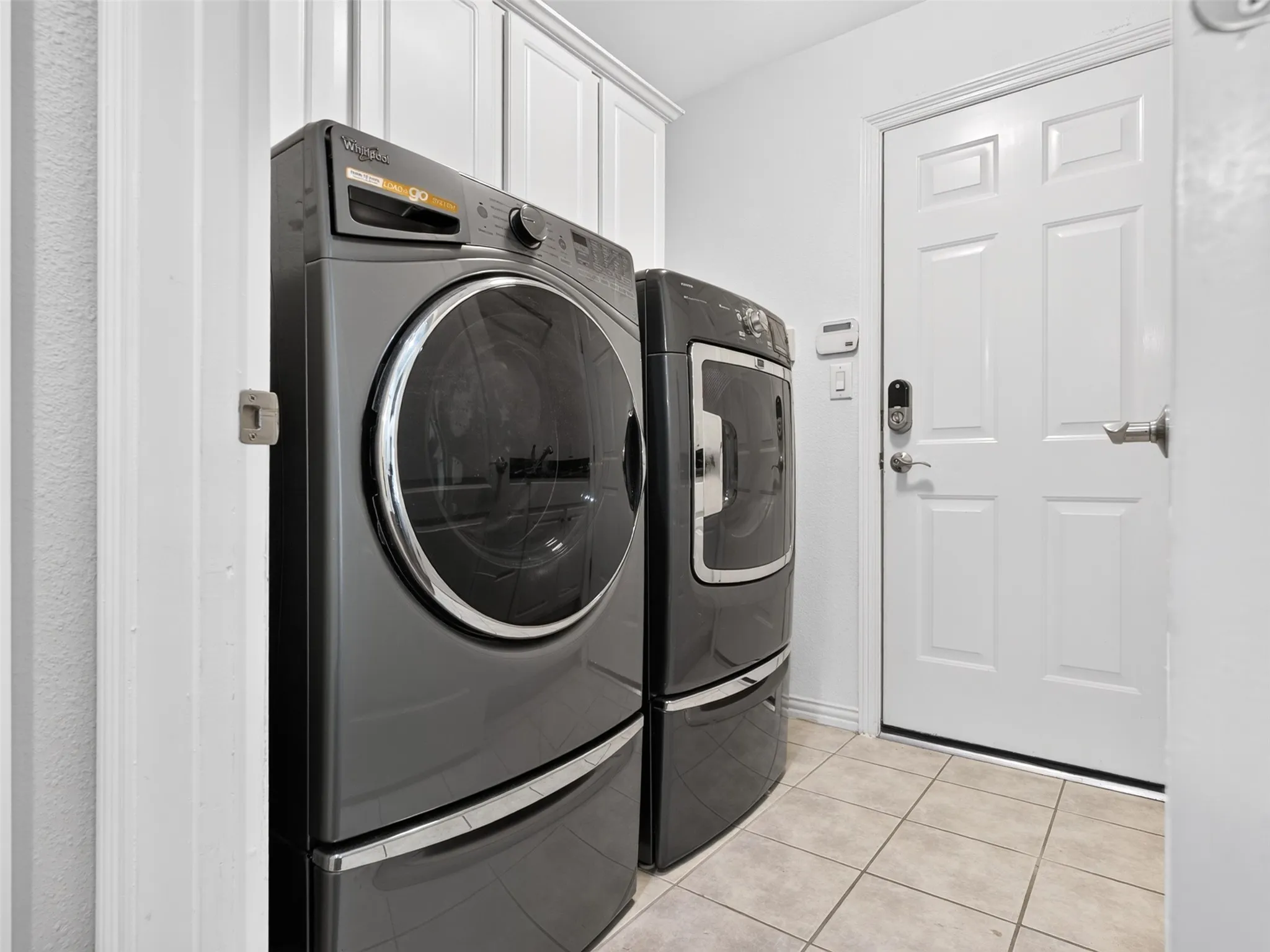 Built-in cabinetry, tile flooring, and white paneled door