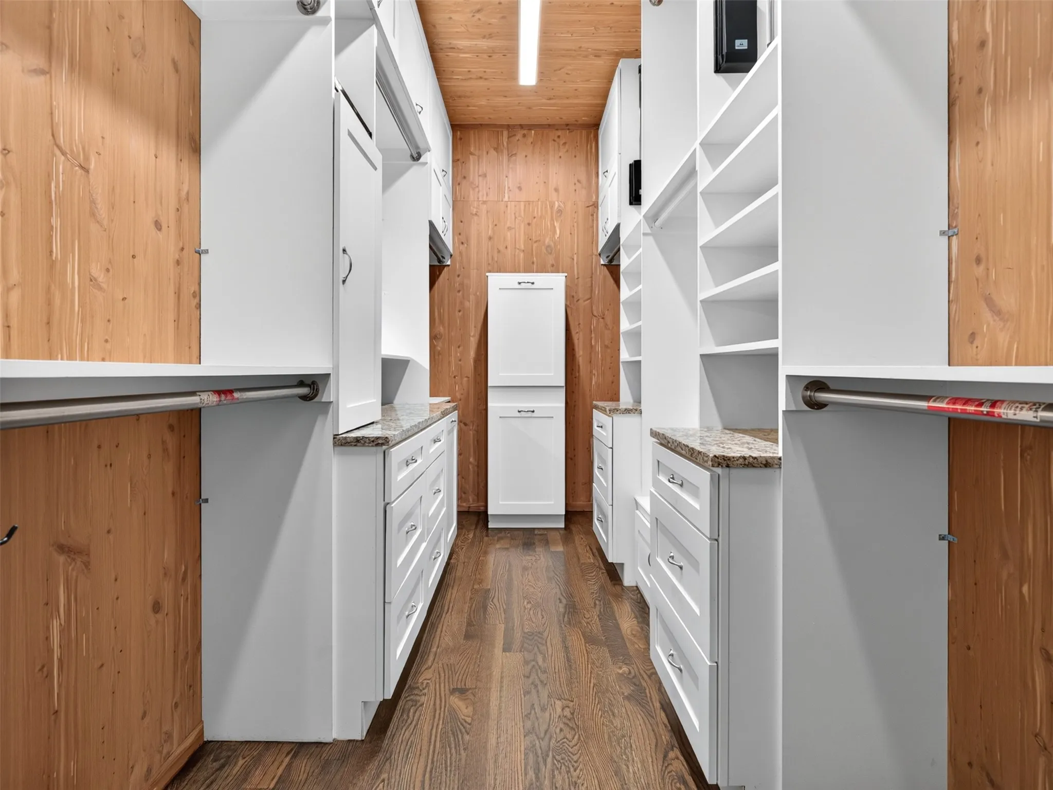 Wood-finish flooring, white built-in cabinetry, granite-finish countertops, cedar-paneled walls, and recessed lighting