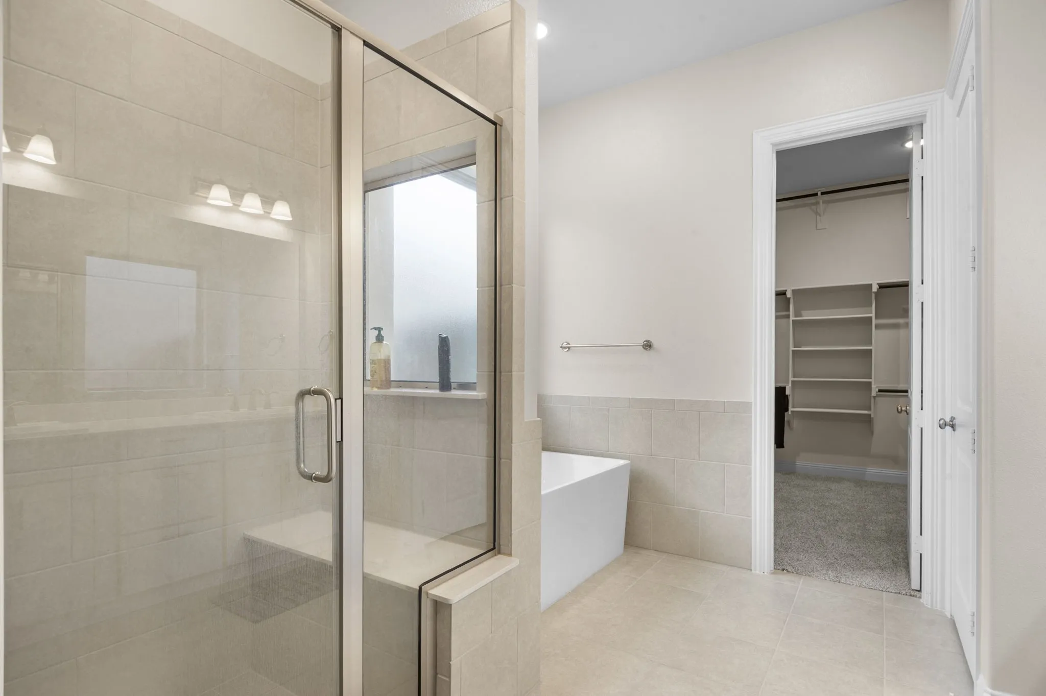 Bathroom with tile walls, shower with separate bathtub, and tile patterned floors