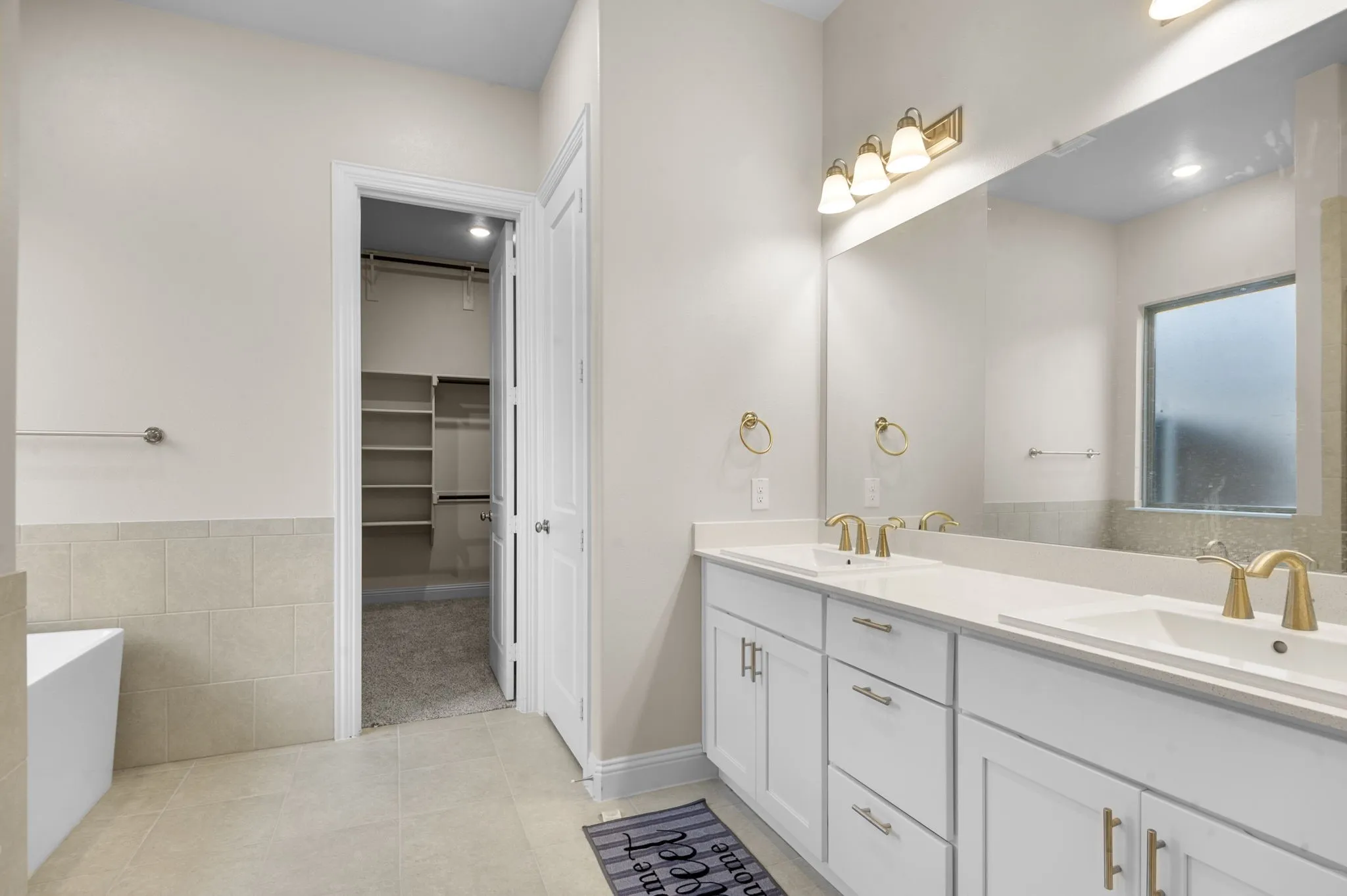 Bathroom with tile patterned flooring, a bathtub, and vanity