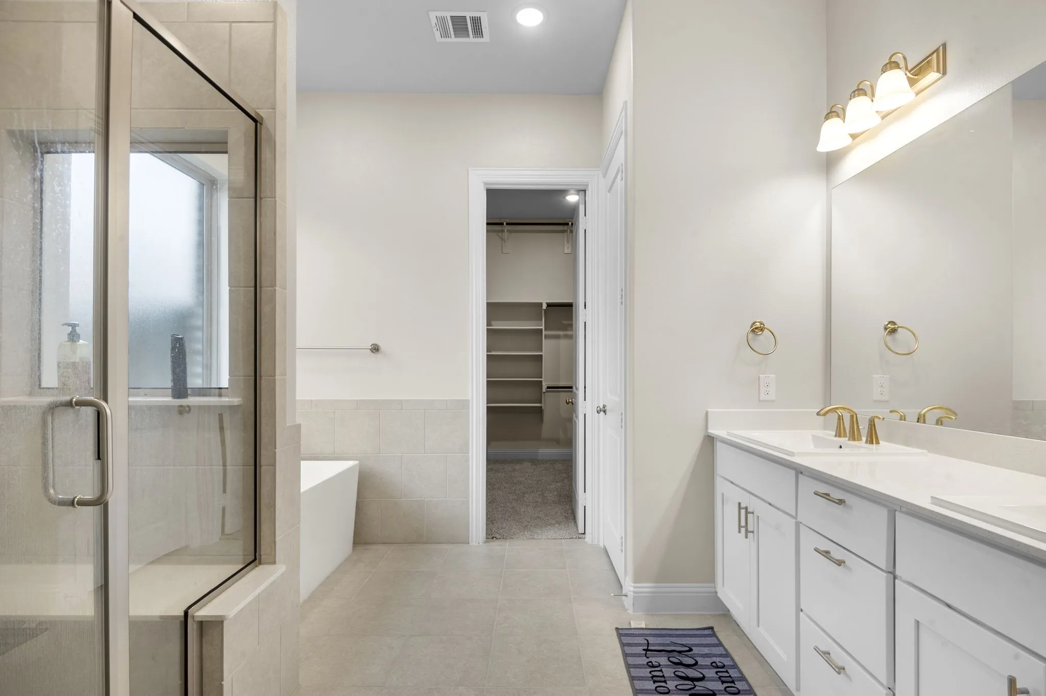 Bathroom with vanity, tile patterned floors, and shower with separate bathtub