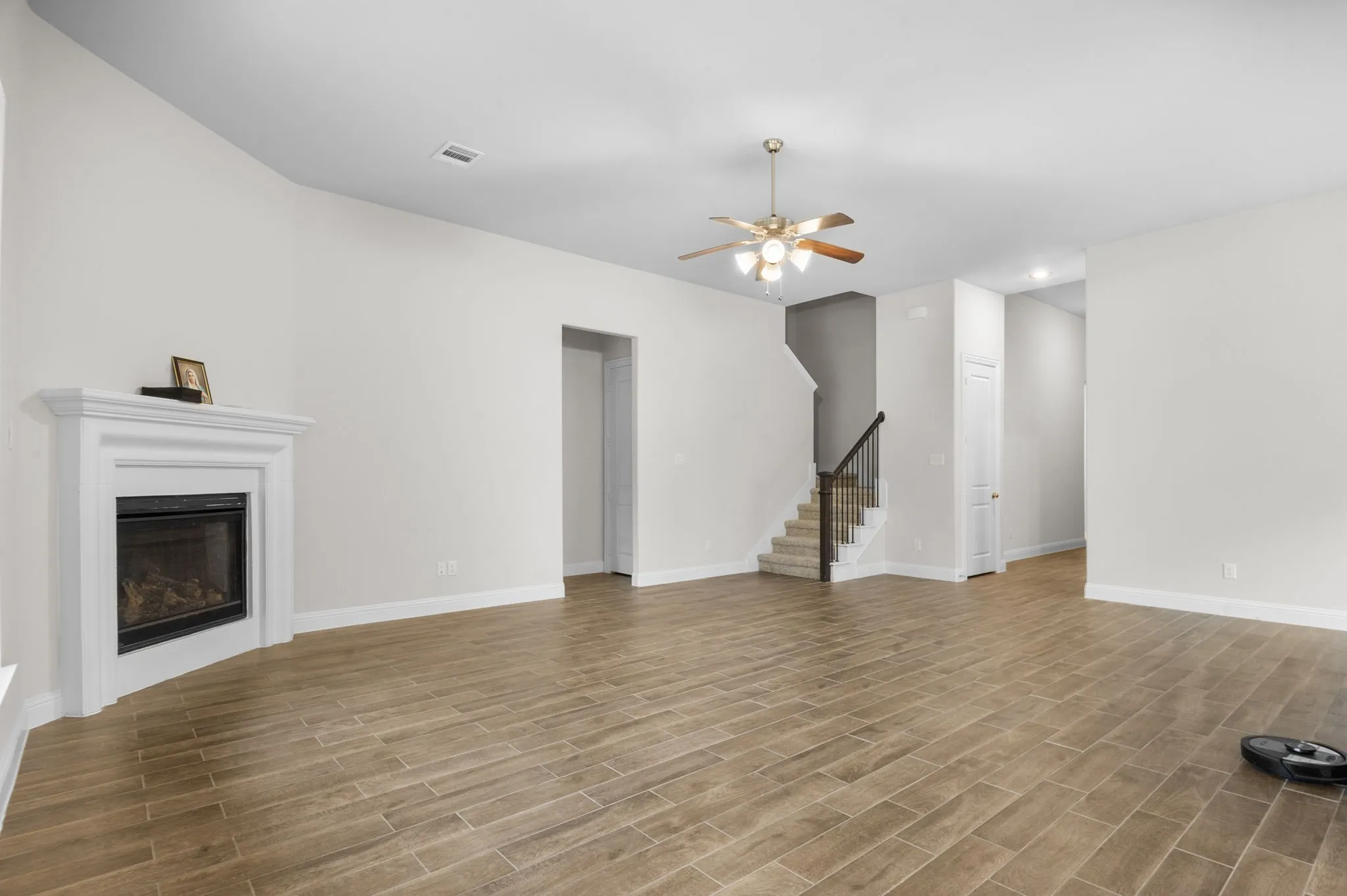 Unfurnished living room with ceiling fan and light wood-type flooring