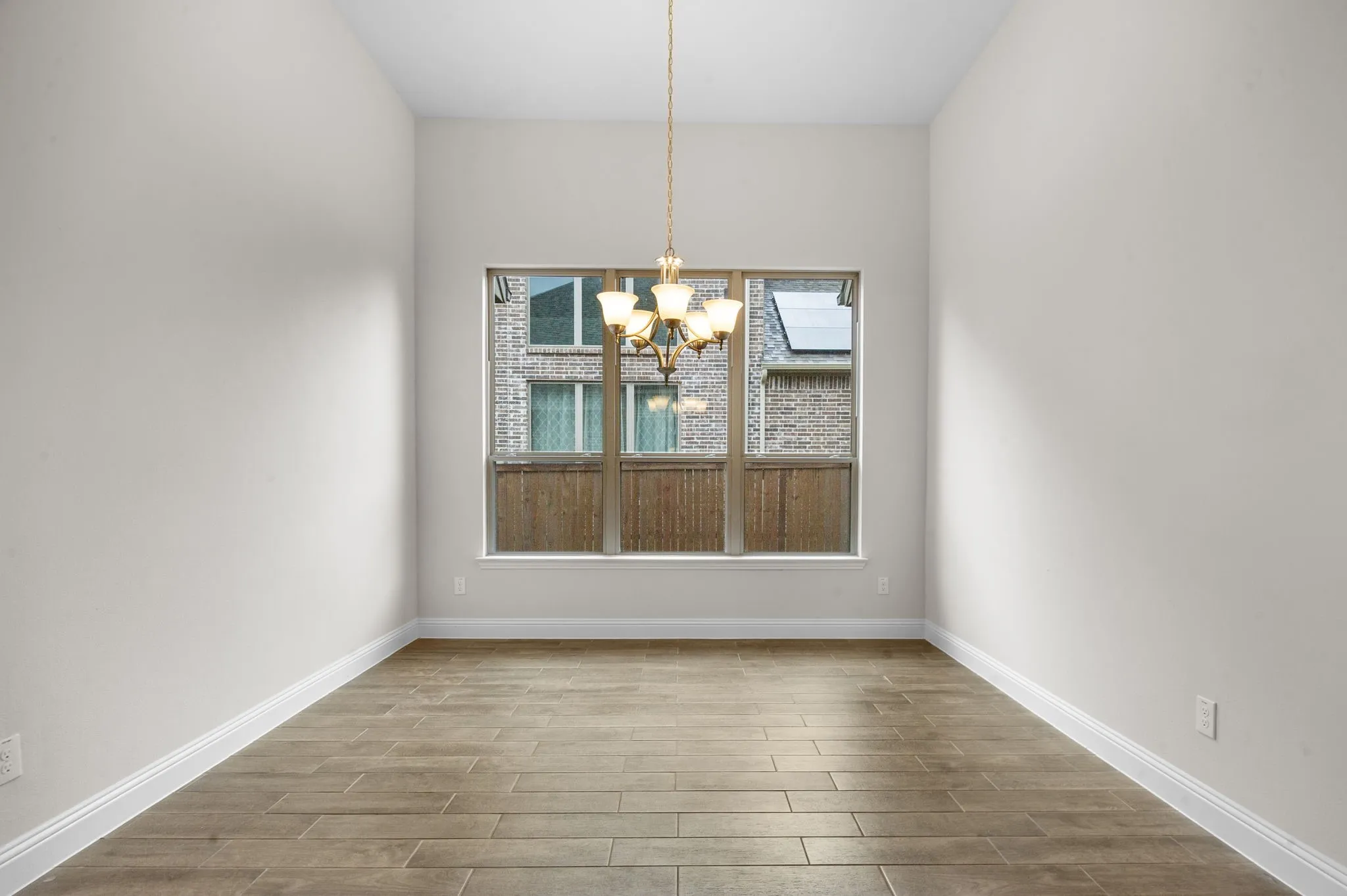 Unfurnished dining area with a healthy amount of sunlight, wood-type flooring, and a chandelier