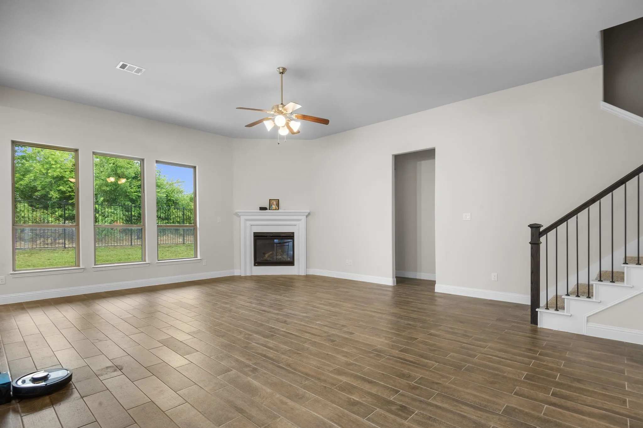 Unfurnished living room with ceiling fan and dark hardwood / wood-style floors