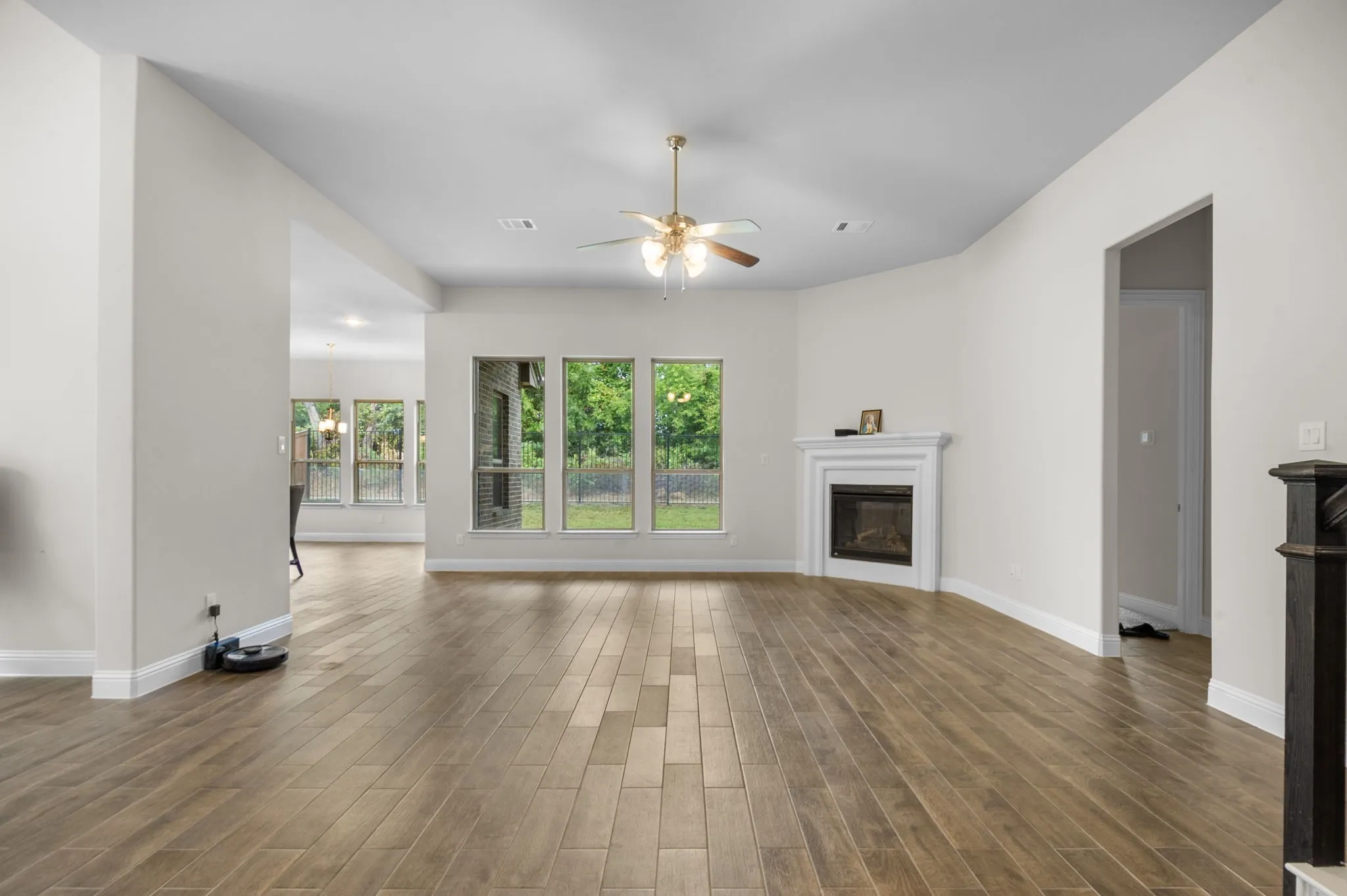 Unfurnished living room featuring ceiling fan and dark hardwood / wood-style floors