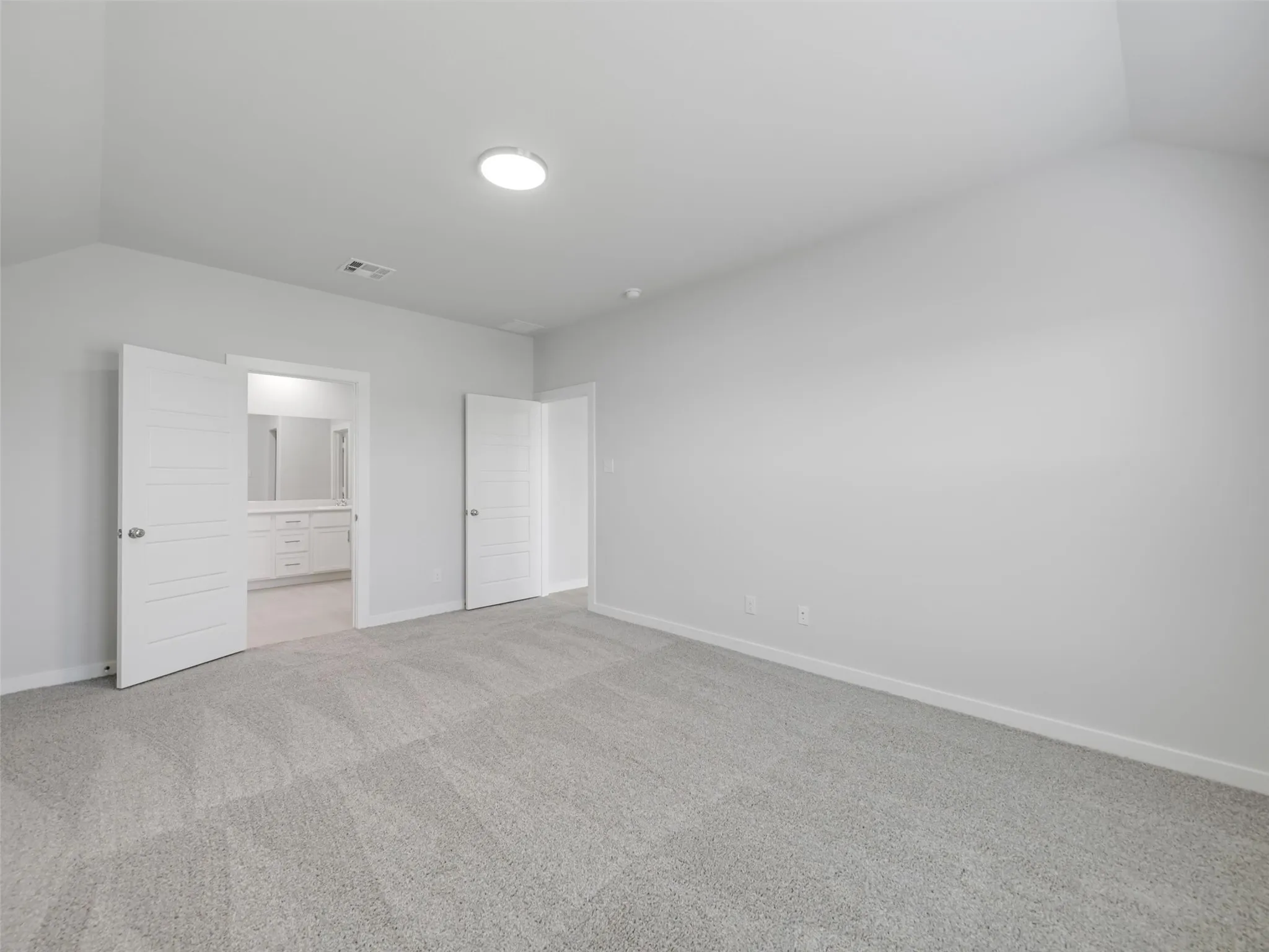 Spacious bedroom featuring neutral wall finishes, recessed ceiling lighting, and plush carpet flooring