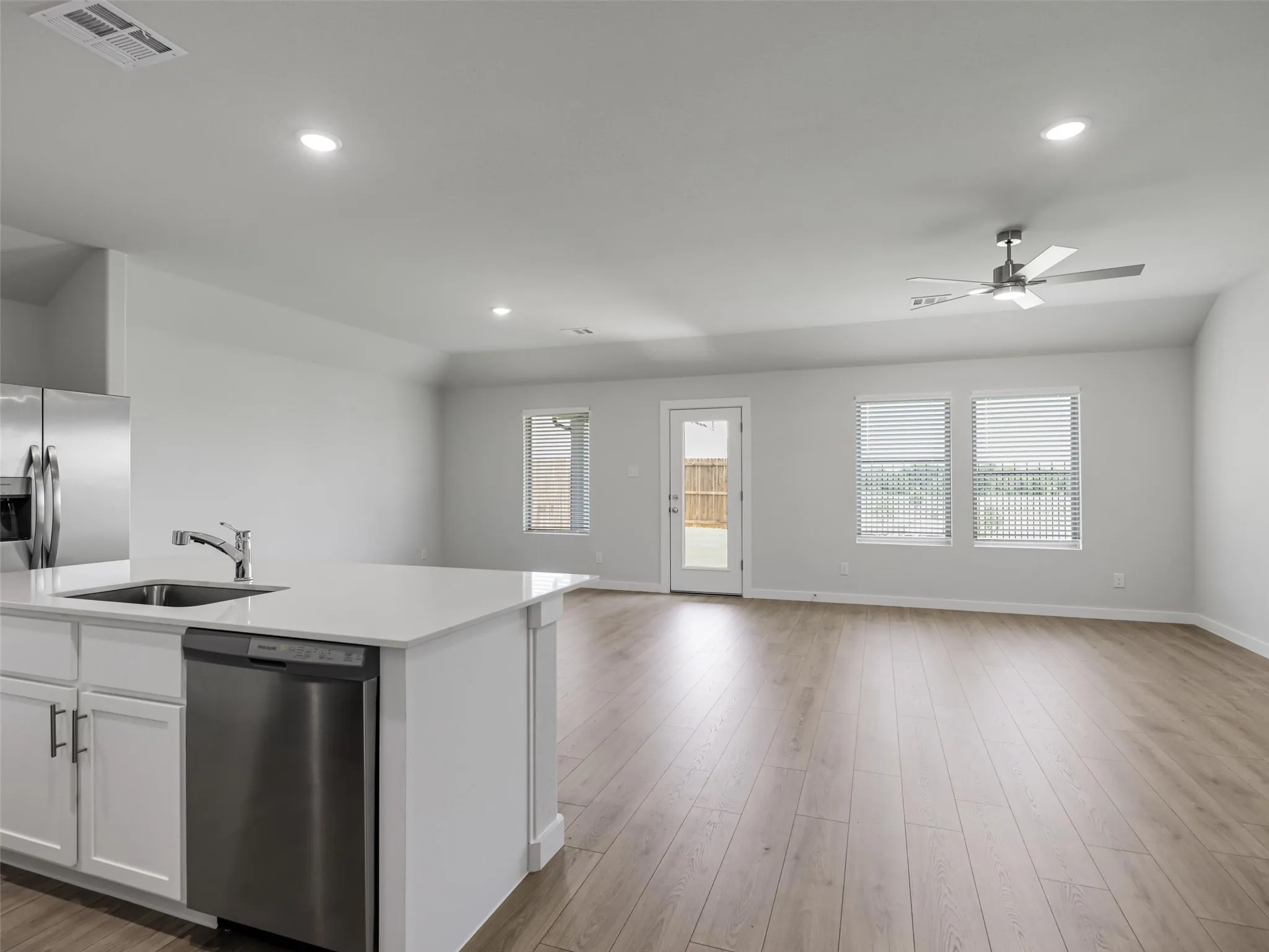 Open-concept living space featuring wood-finish flooring, recessed lighting, and a contemporary ceiling fan