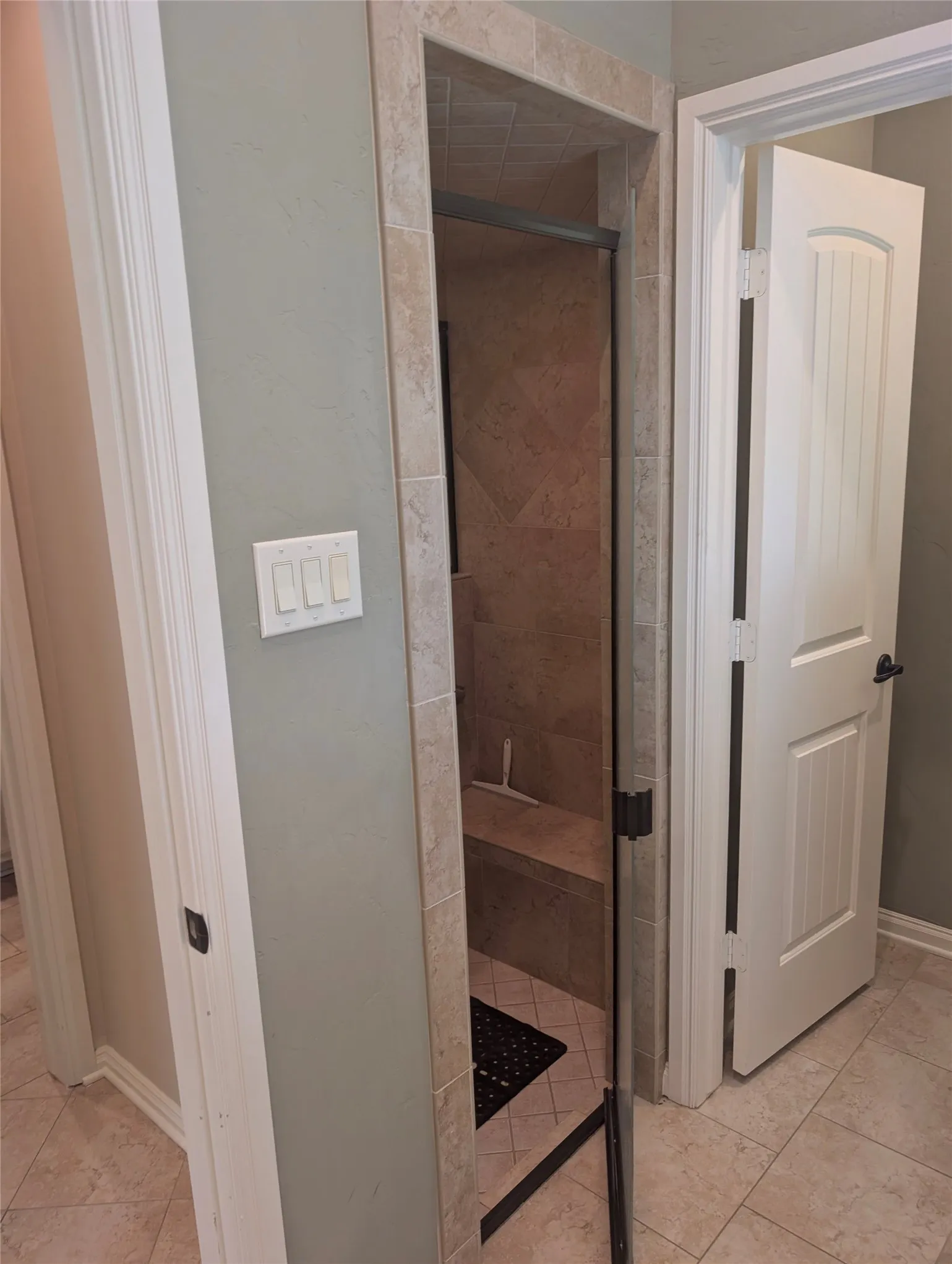 One side of the walk-through shower and access to toilet room