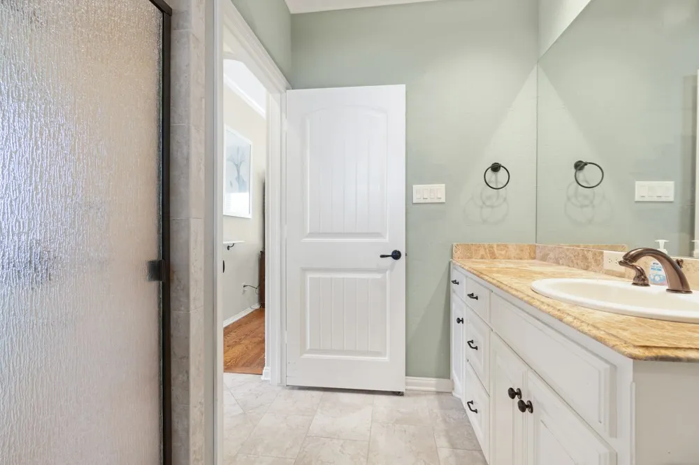 Other side of primary bathroom with separate vanity, sink, toilet and walk-through shower.