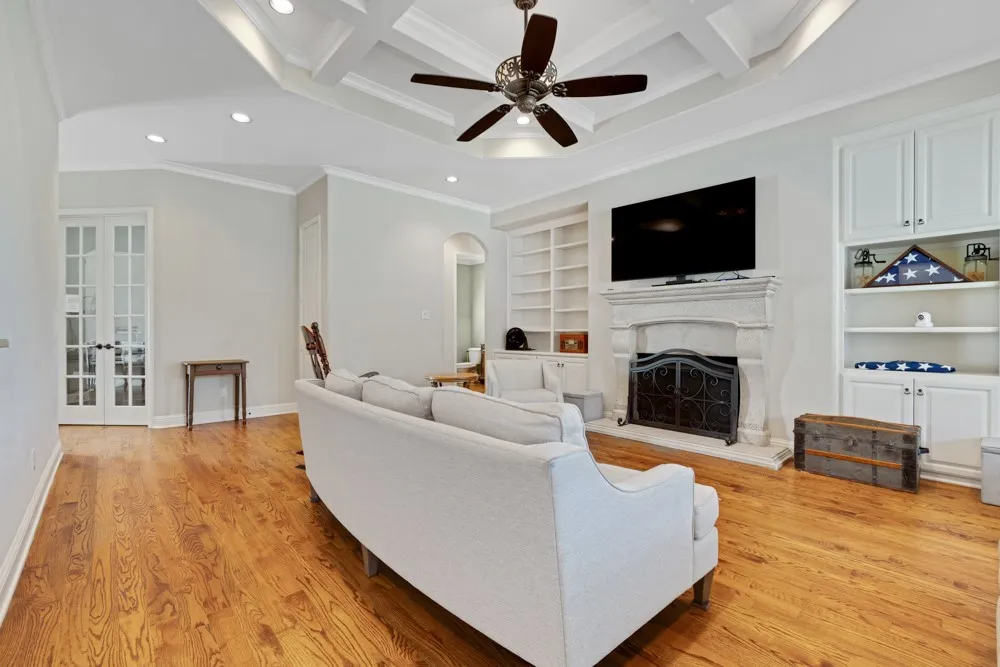 Light and bright living area with built ins and a fireplace. Office or second living room is behind the French doors.