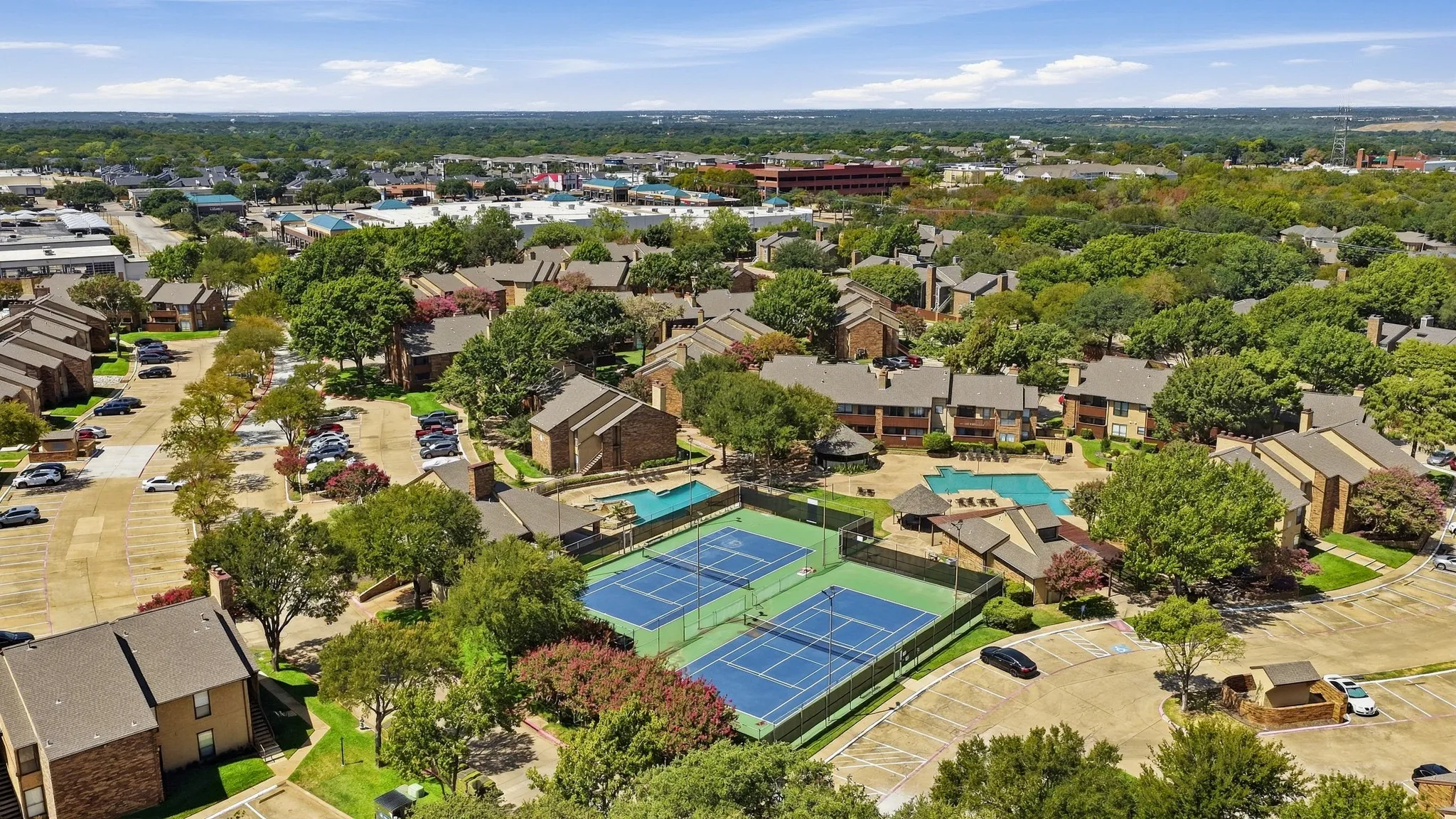 view of two pools and tennis courts