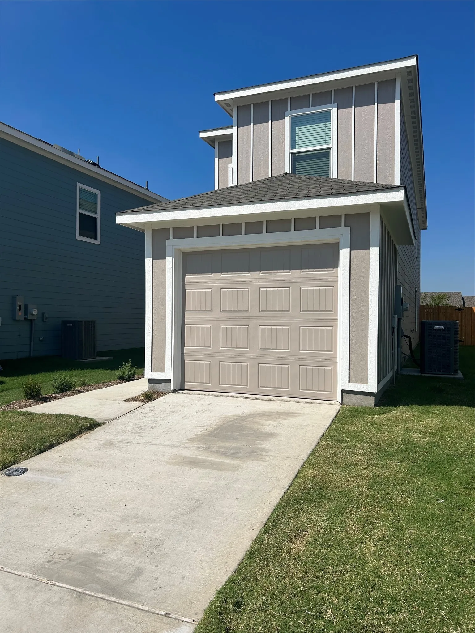 Garage featuring a yard and central AC unit