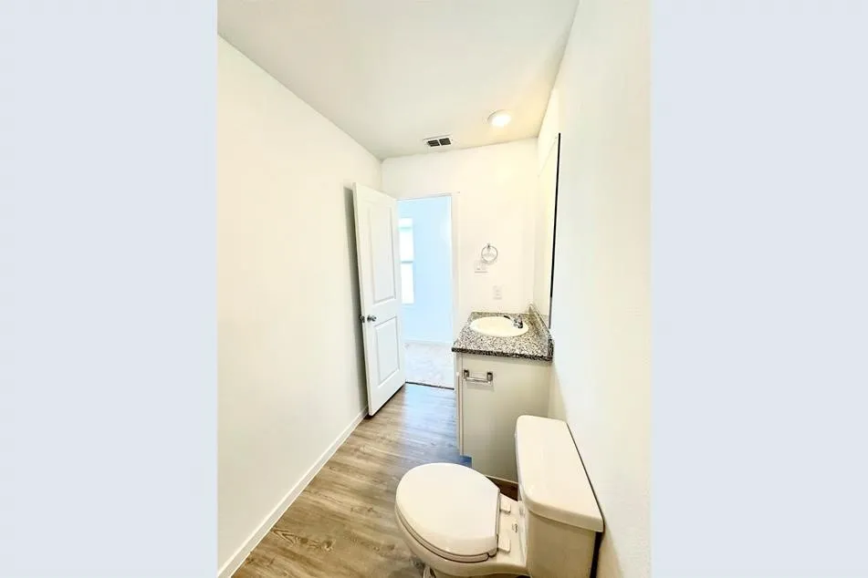 Hall with light hardwood / wood-style floors and sink