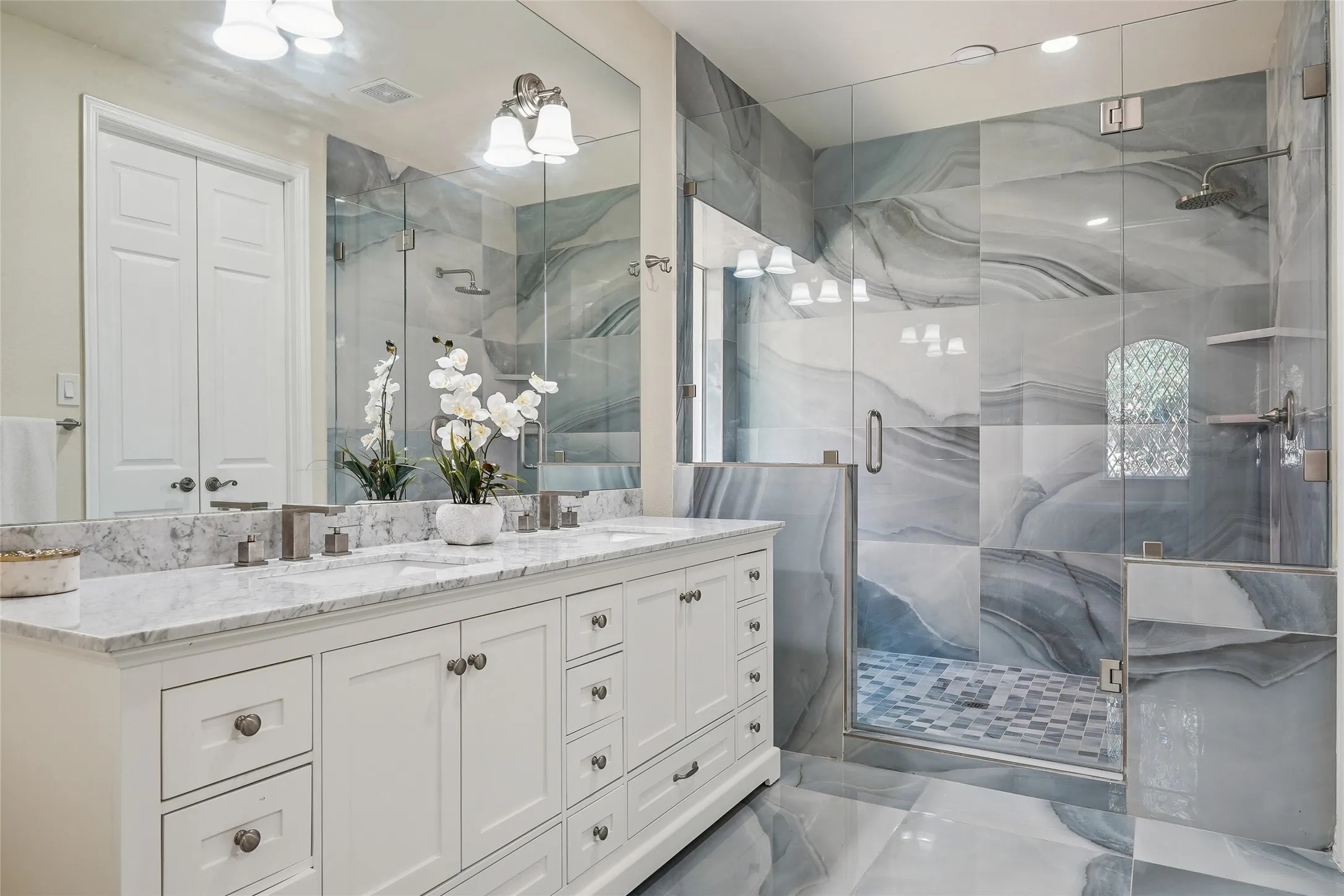 Spacious bathroom featuring a dual vanity with white cabinetry and a light-colored countertop
