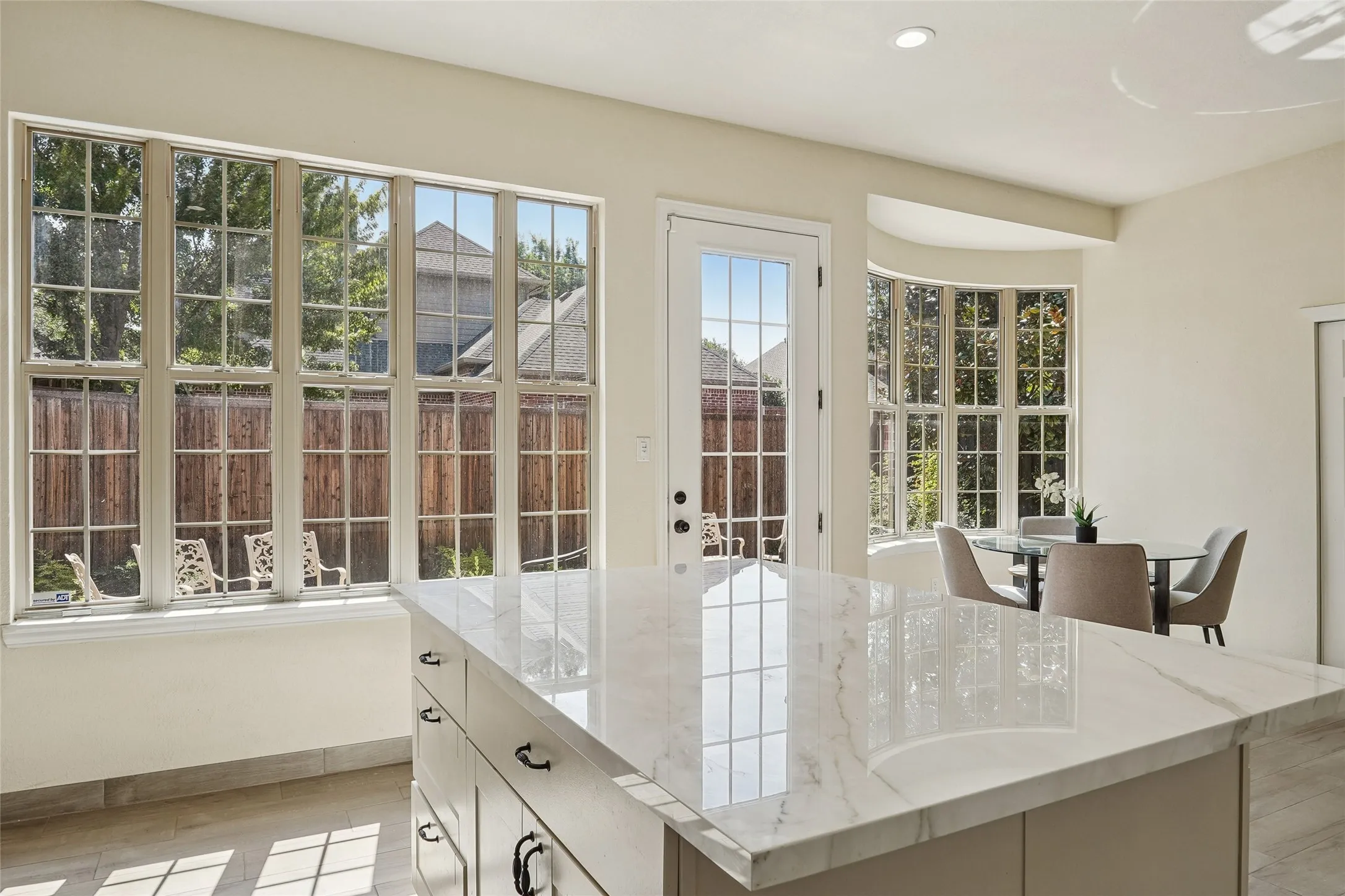 2nd Kitchen island with a polished countertop, integrated cabinetry with dark hardware, and a tile​​‌​​​​‌​​‌‌​‌‌​​​‌‌​‌​‌​‌​​​‌​​ backsplash