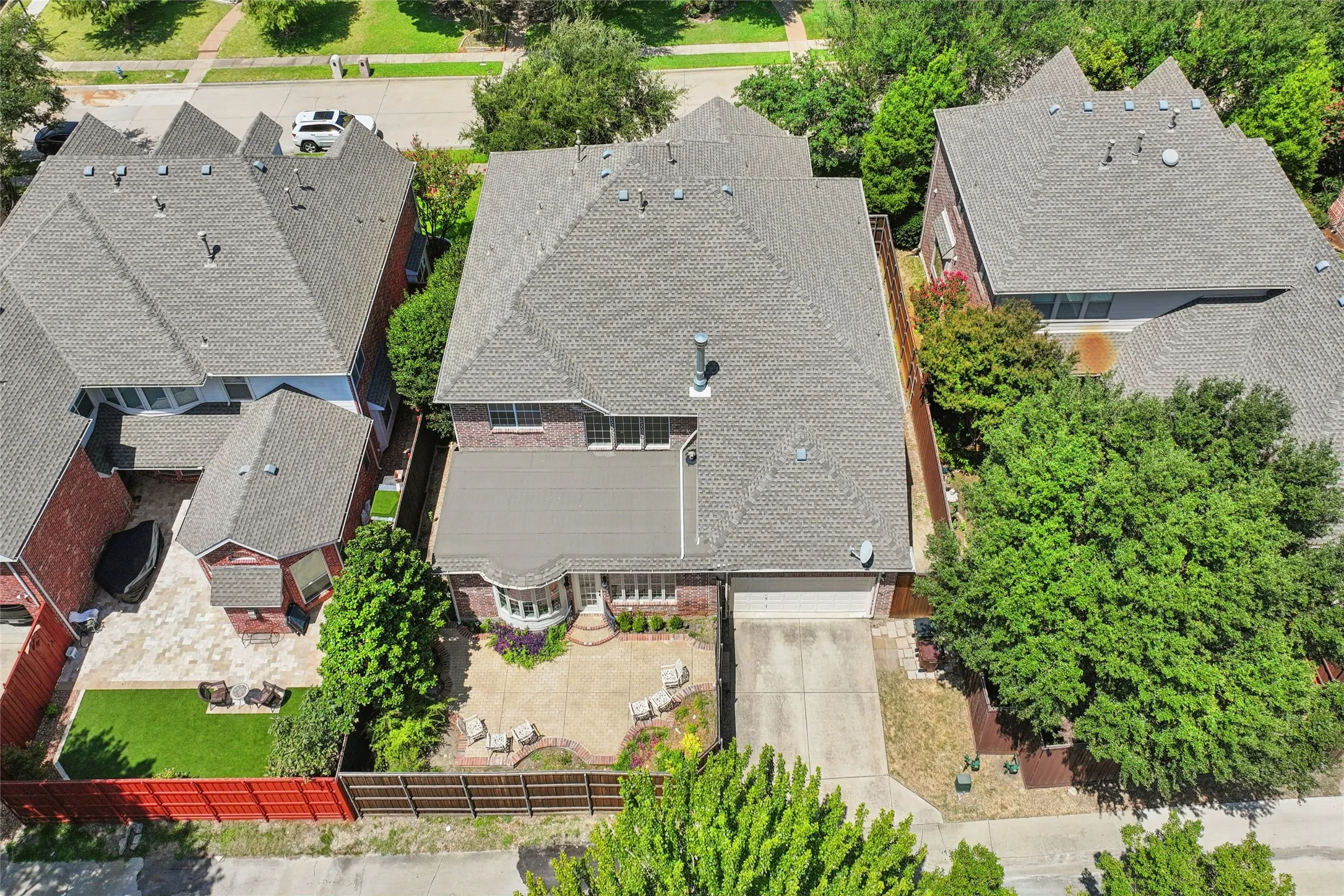 Two-story brick residence featuring a multi-pitched roofline and an attached two-car garage