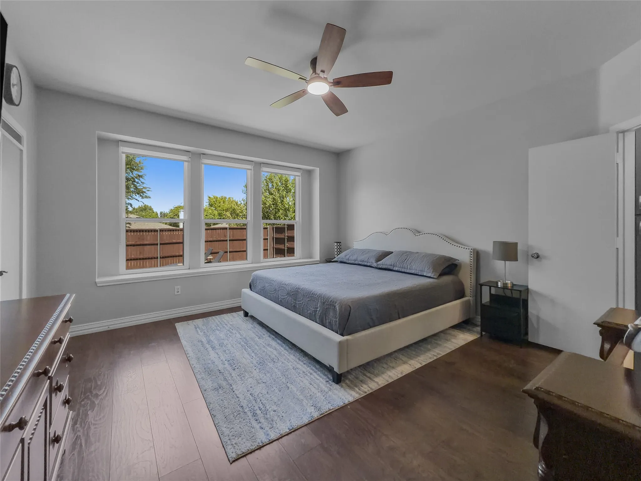 Recessed lighting, wood-finish flooring, a ceiling fan, and three large windows