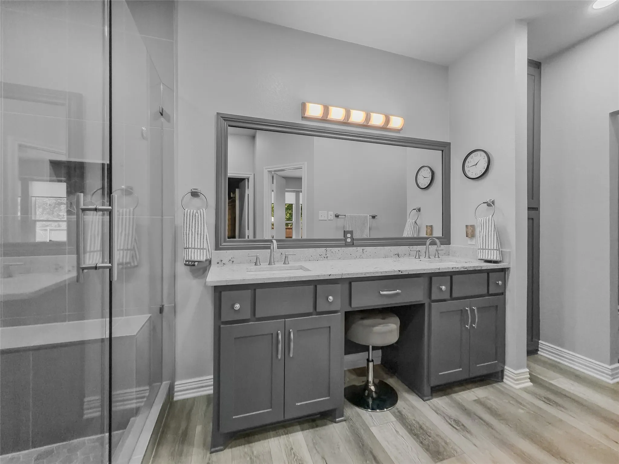 Dual vanity with white undermount sinks, stone-finish countertop, and gray shaker cabinetry
