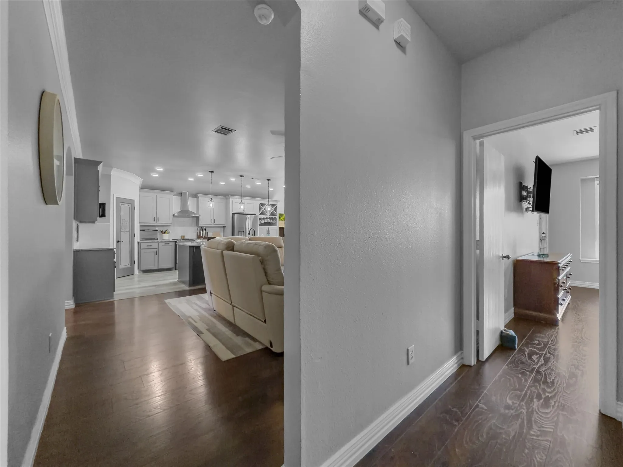 Dark wood-finish flooring throughout, light gray wall paint, and white trim molding
