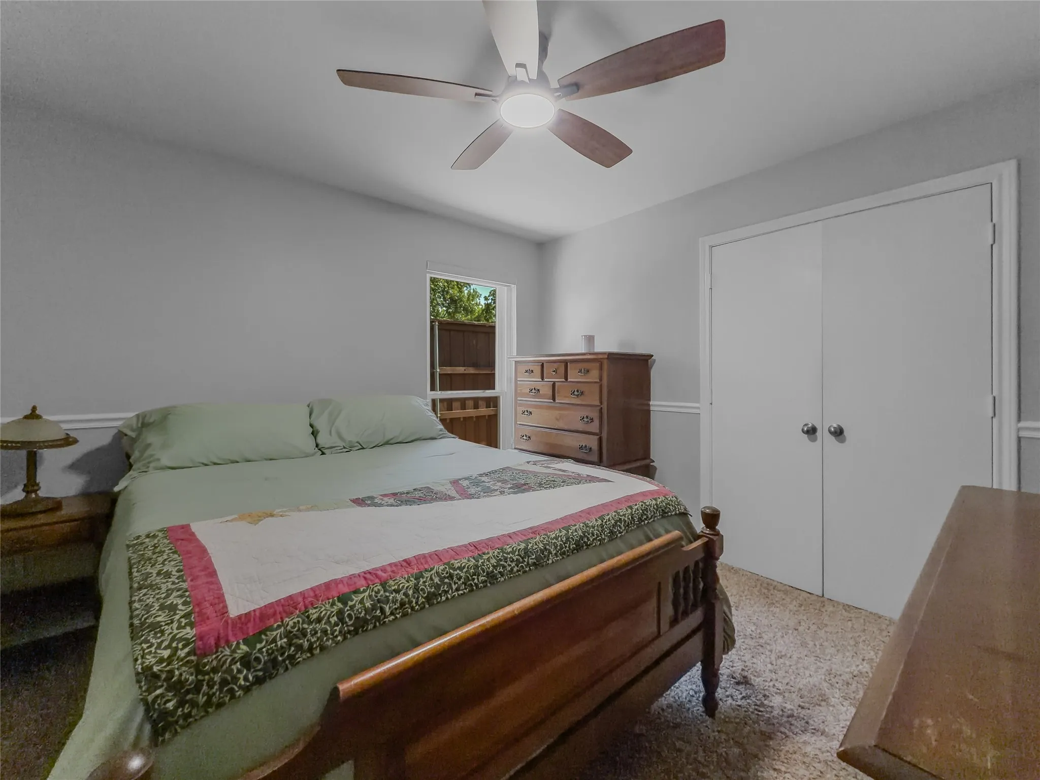 Neutral wall paint, ceiling fan with integrated lighting, window with exterior view, and built-in closet with double doors