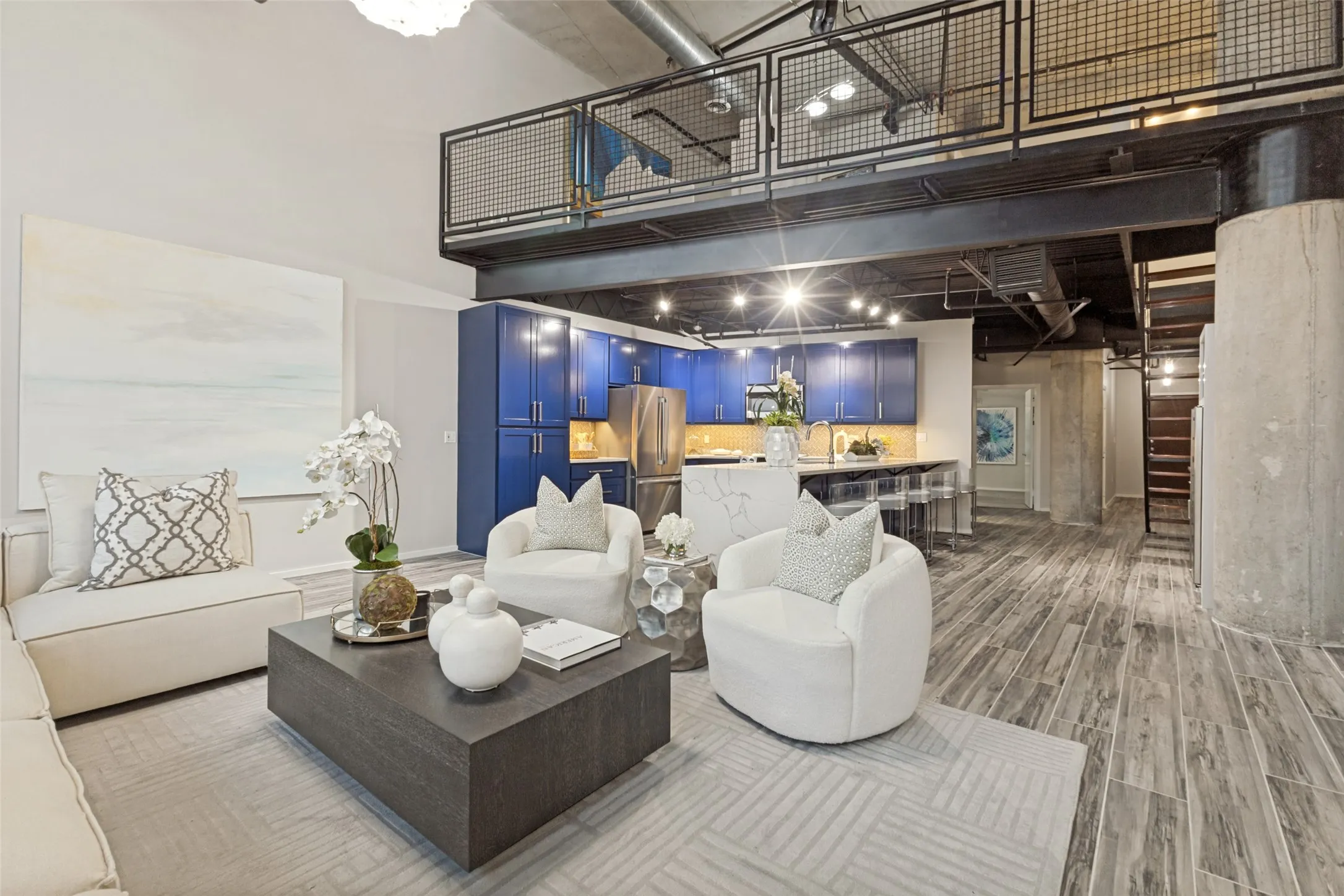 Two-story living area featuring floor-to-ceiling windows, exposed ductwork, wood-finish flooring, and a contemporary chandelier