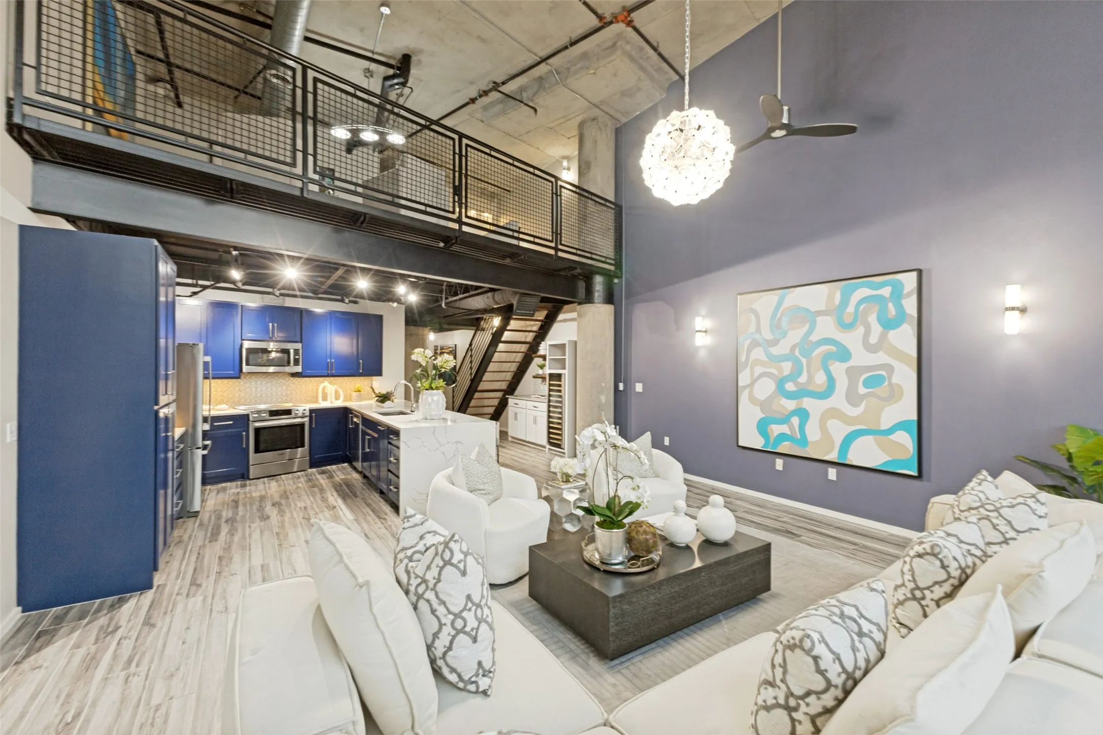 Contemporary kitchen and dining space featuring white shaker cabinetry with integrated appliances, quartz countertops, and stainless steel hardware