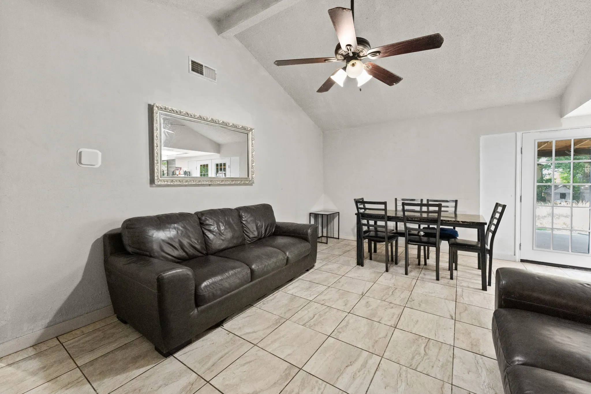 Vaulted ceiling featuring a ceiling fan with light fixture