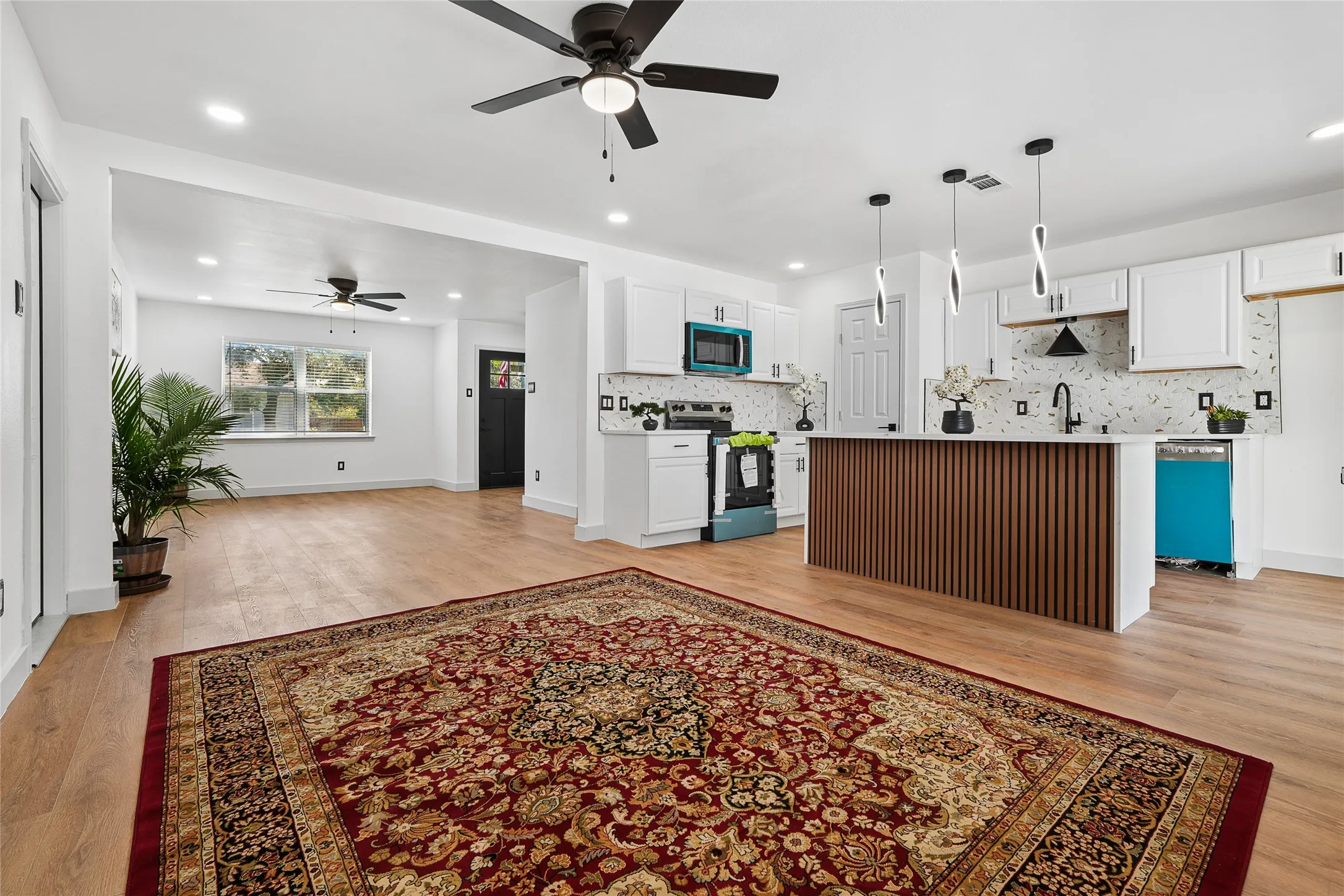 Open-concept living space featuring hardwood flooring, recessed ceiling lighting, and ceiling fans throughout