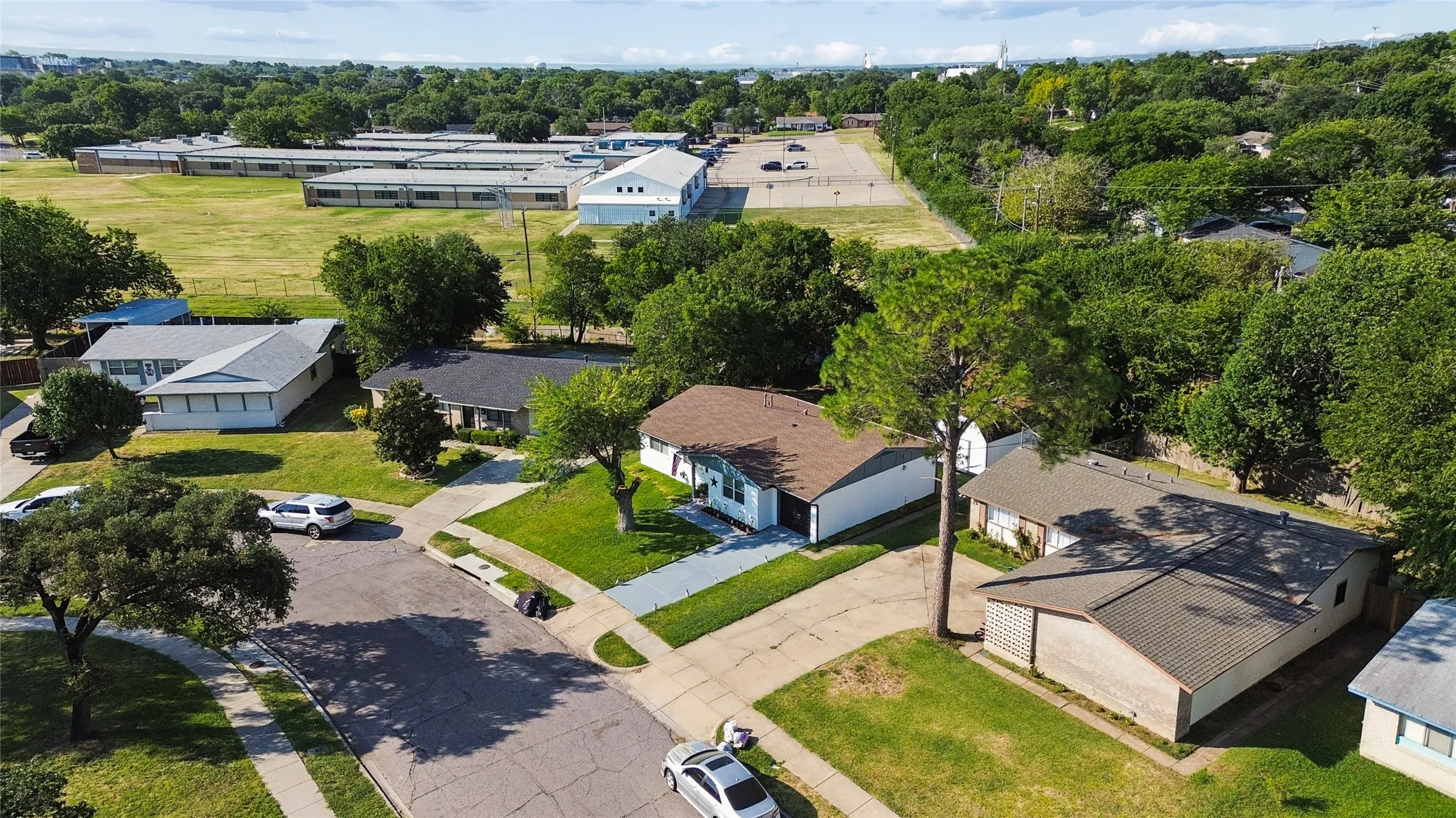 Residential neighborhood with mature trees, established properties, and paved streets