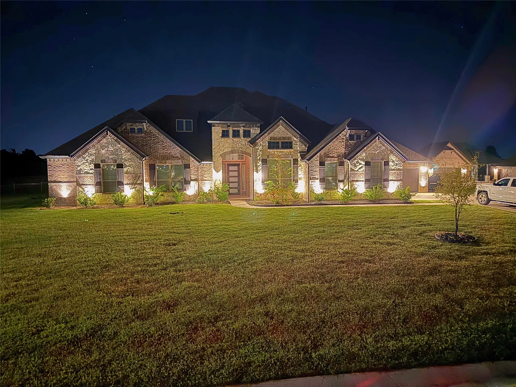 Elegant brick and stone residence showcasing a grand facade with multiple gables, arched entryways, and abundant architectural detail