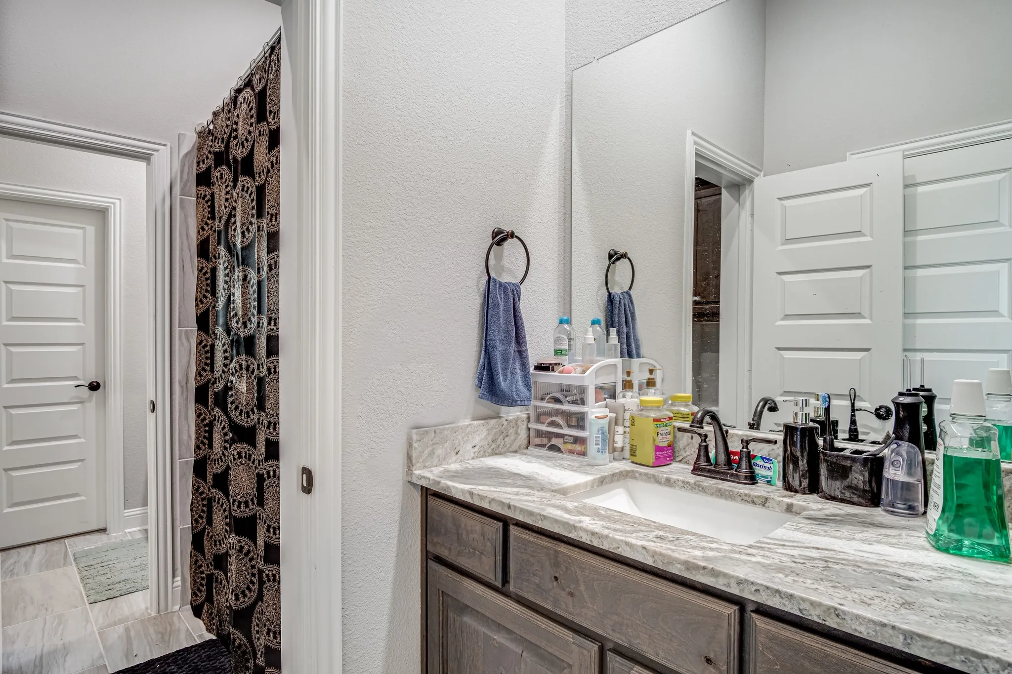 Vanity featuring a single undermount sink, a dark bronze faucet, and a stone countertop