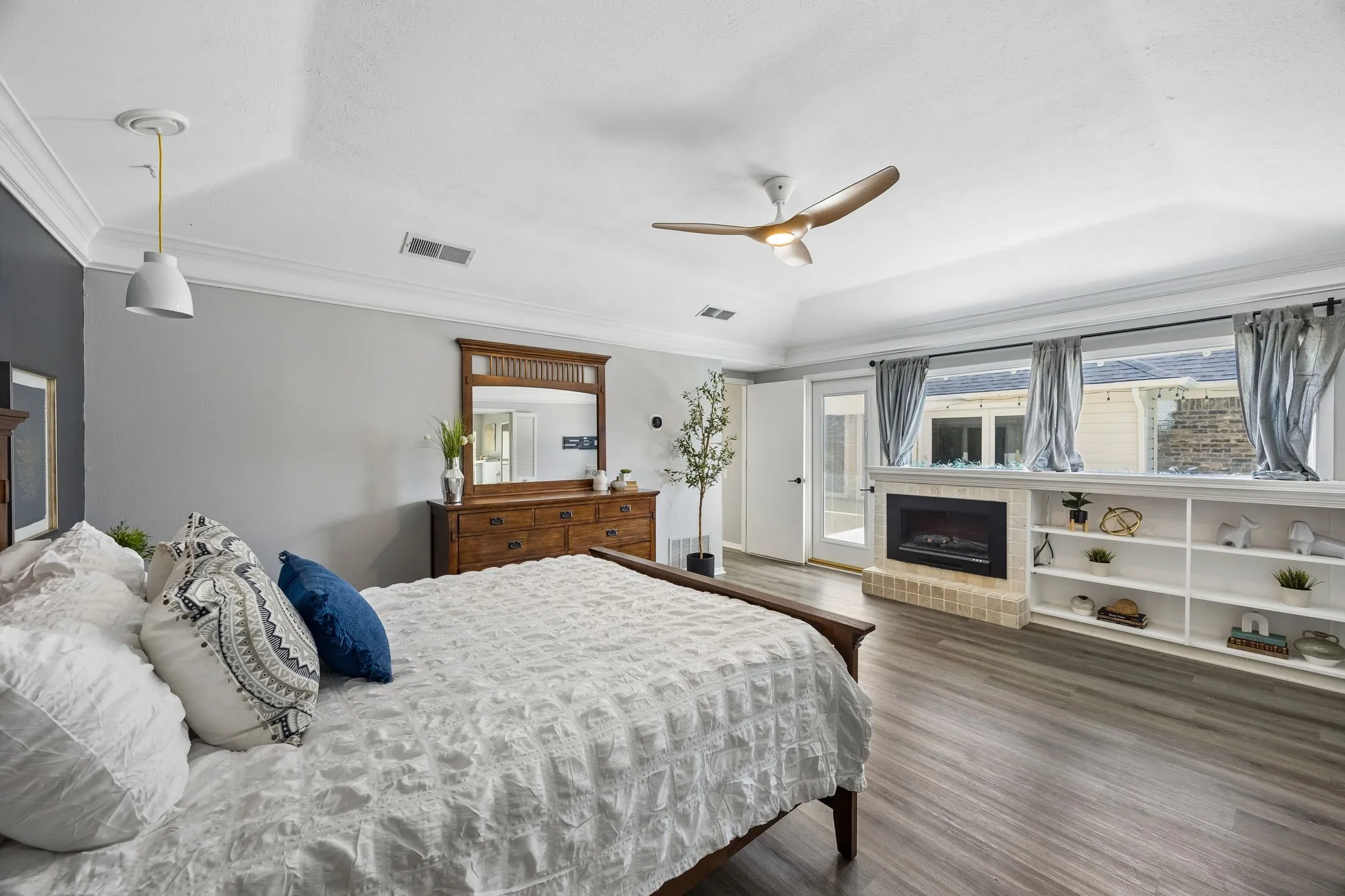 Spacious room featuring wood-finish flooring, a contemporary ceiling fan, and crown molding