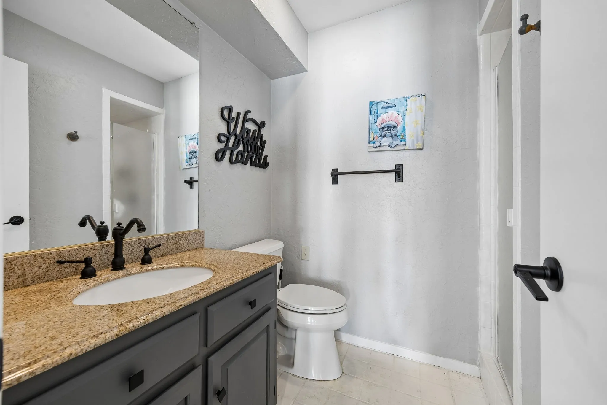 Bathroom vanity featuring a granite countertop with an undermount sink and dark cabinetry