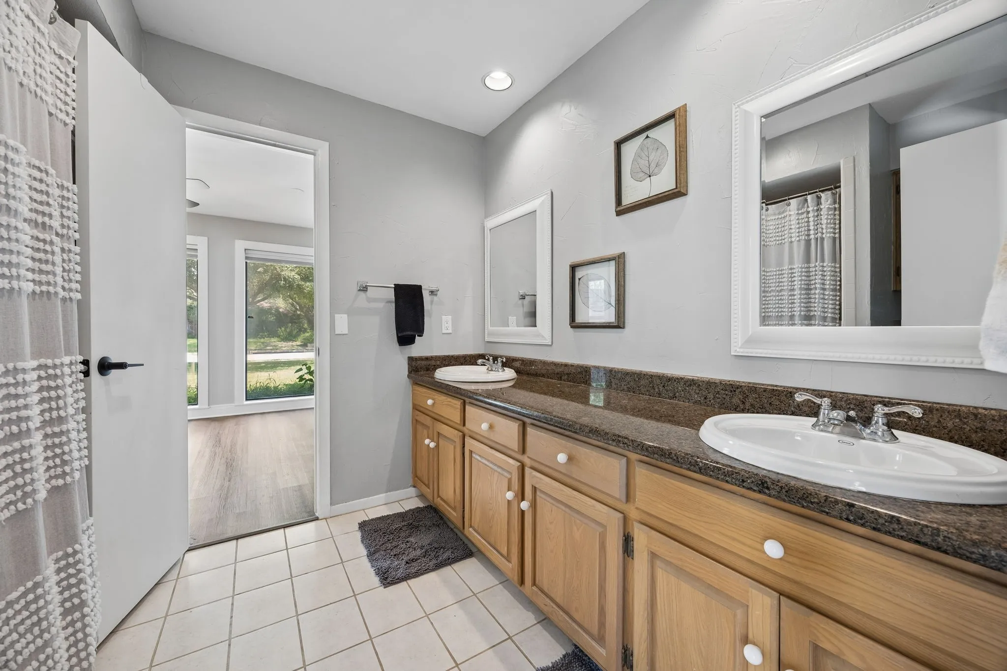 Double vanity with integrated sinks, granite-finish countertop, and wood-tone cabinetry