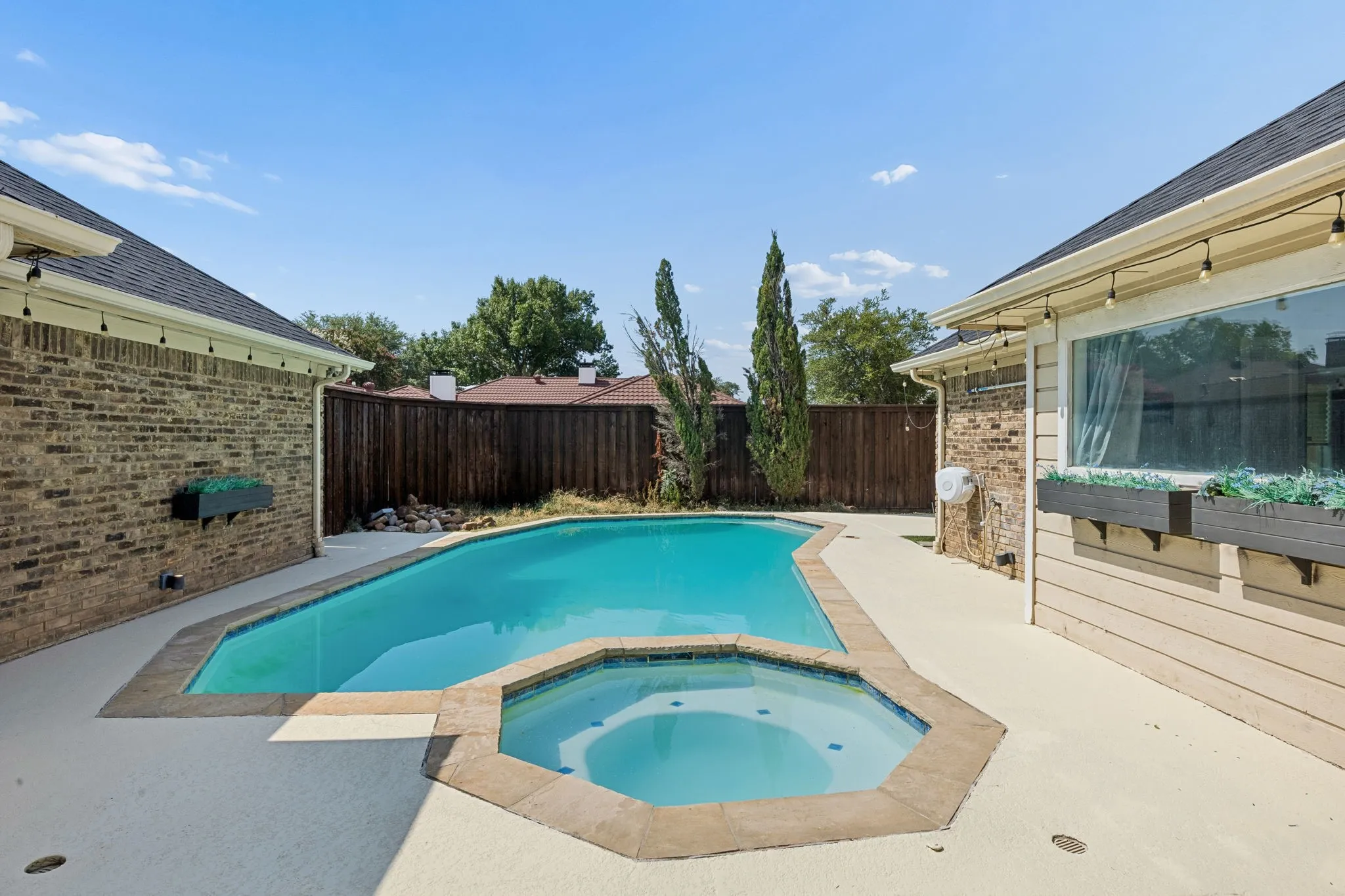 In-ground pool and spa with surrounding concrete decking