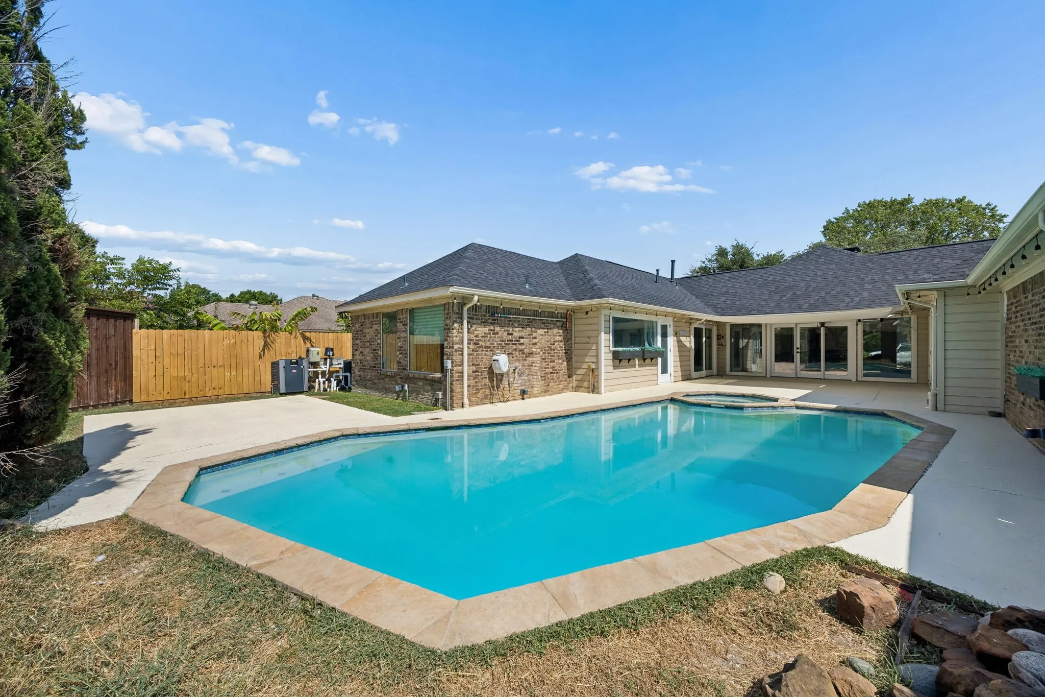 Private backyard featuring an in-ground swimming pool with an integrated spa